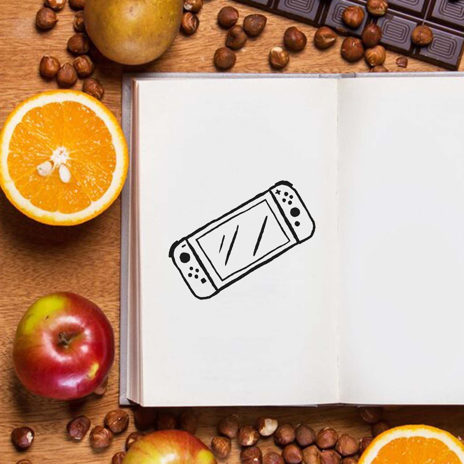 Handheld game console rubber stamp design on open notebook, ideal for gaming-themed crafts, journals, and planner pages.