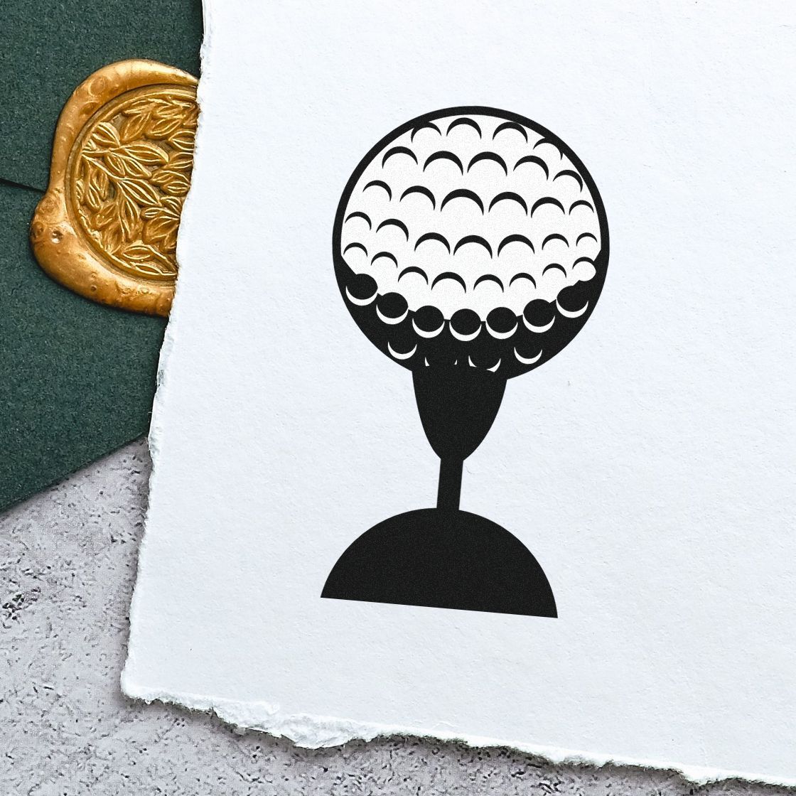 Golf ball on tee rubber stamp impression on white paper for golf-themed stationery, crafts, and custom stamp designs.