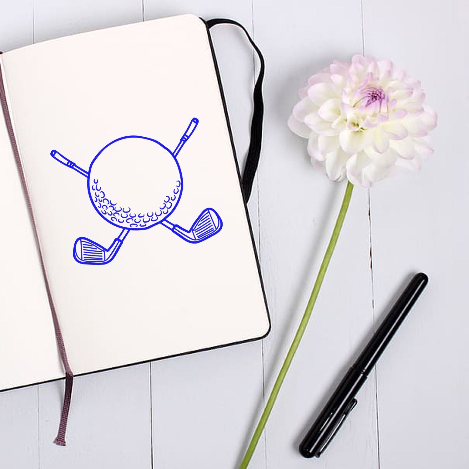 Golf ball and clubs rubber stamp design on notebook, ideal for custom golf-themed stationery, crafting, and scrapbooking.