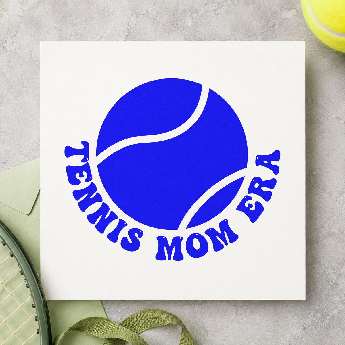Tennis Mom Era Ball craft stamp imprinted in blue ink on paper, a design suited to framed garage hook.