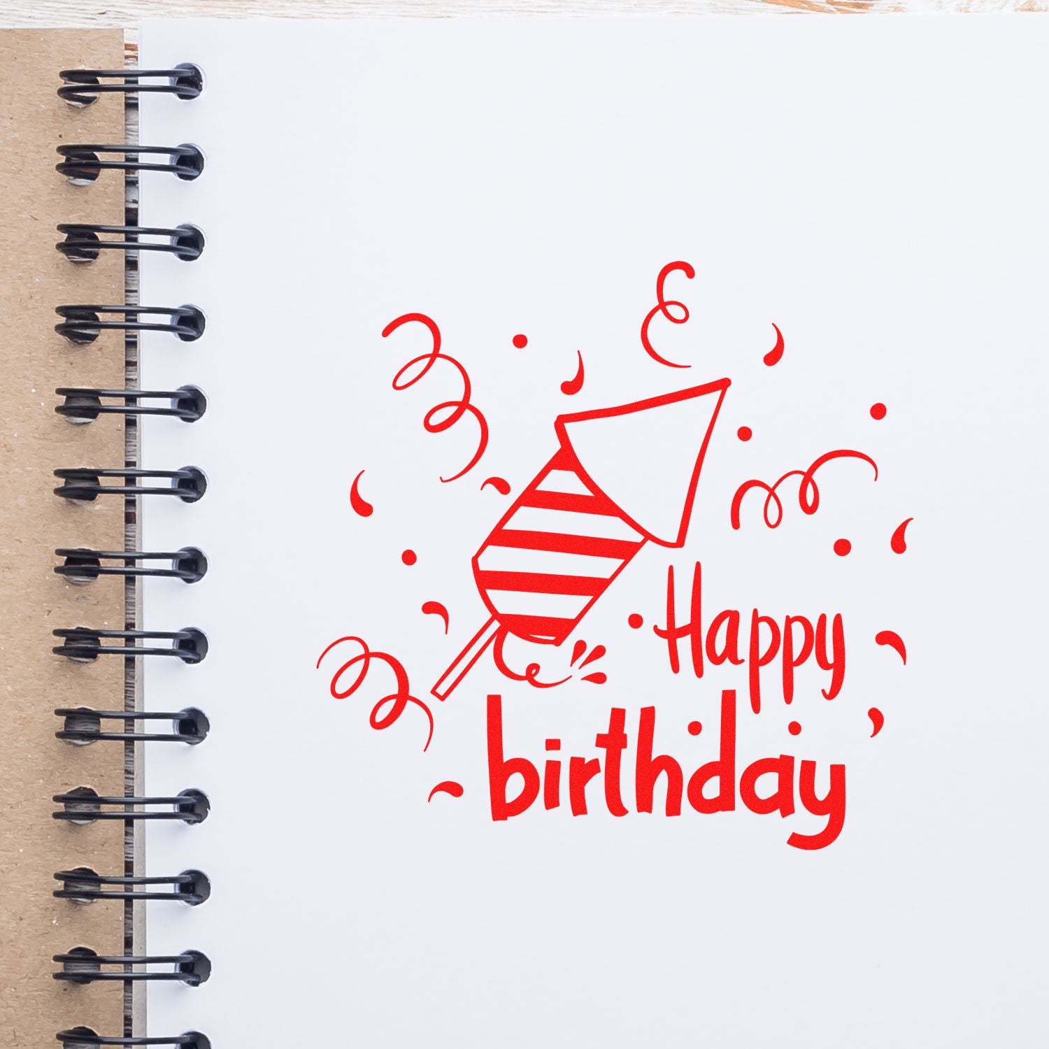 Red happy birthday rubber stamp on notebook paper, ideal for party cards, scrapbooking, and custom birthday crafts.