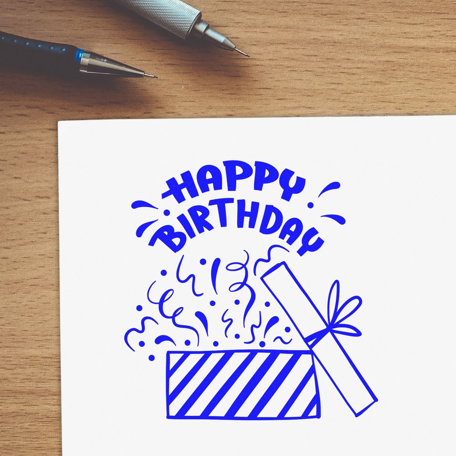 Happy Birthday rubber stamp design with party popper on white paper, ideal for birthday cards and handmade crafts.