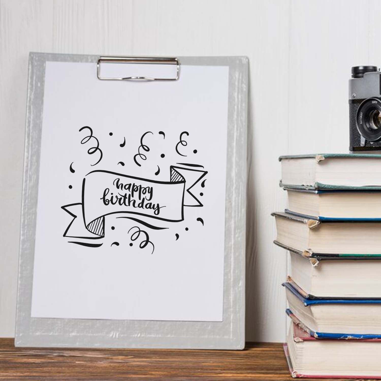 Happy birthday rubber stamp design on clipboard, ideal for handmade birthday cards, scrapbooking, and craft projects.