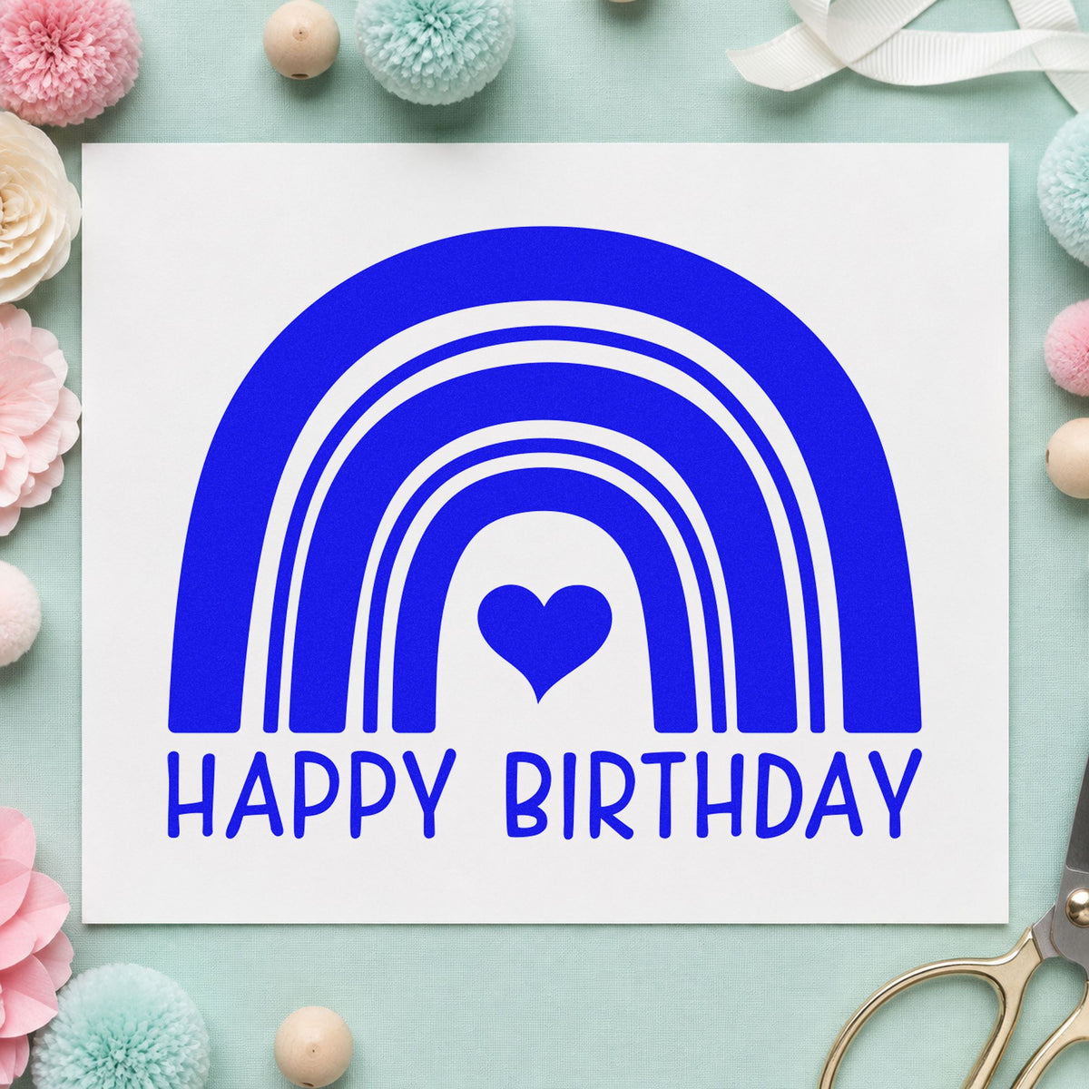 Happy Birthday Heart Rainbow craft stamp imprinted in blue ink on paper, a design suited to framed party corner.