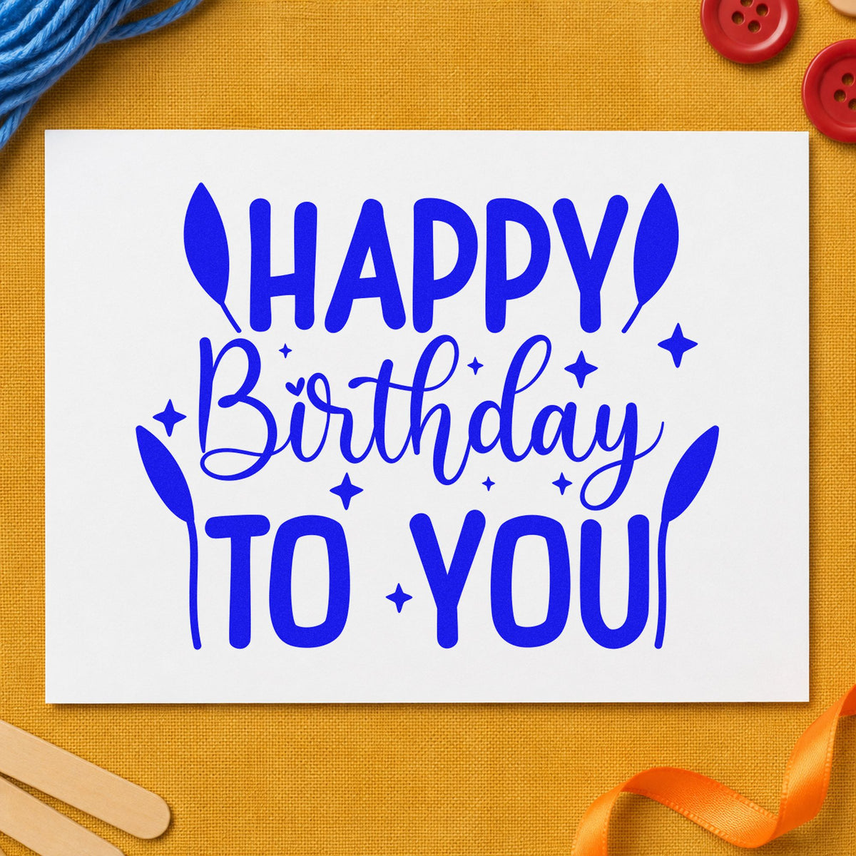 Happy Birthday To You craft stamp in blue ink on cardstock, an easy option for screen backdrop printing.