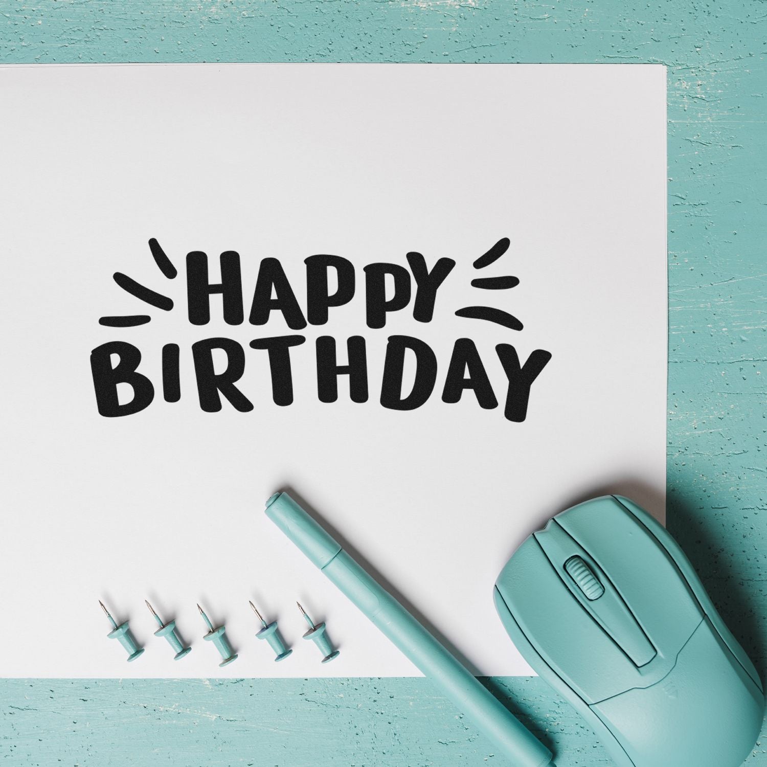 Custom Happy Birthday rubber stamp mockup with mint stamping tools on white paper.