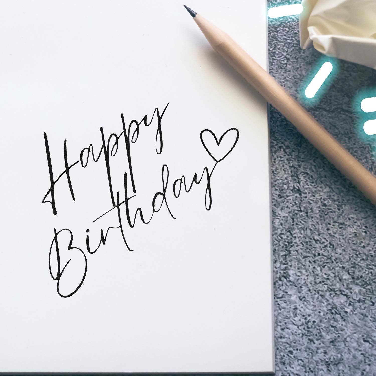 Happy Birthday rubber stamp design in handwritten script with heart, ideal for birthday cards and handmade crafts.