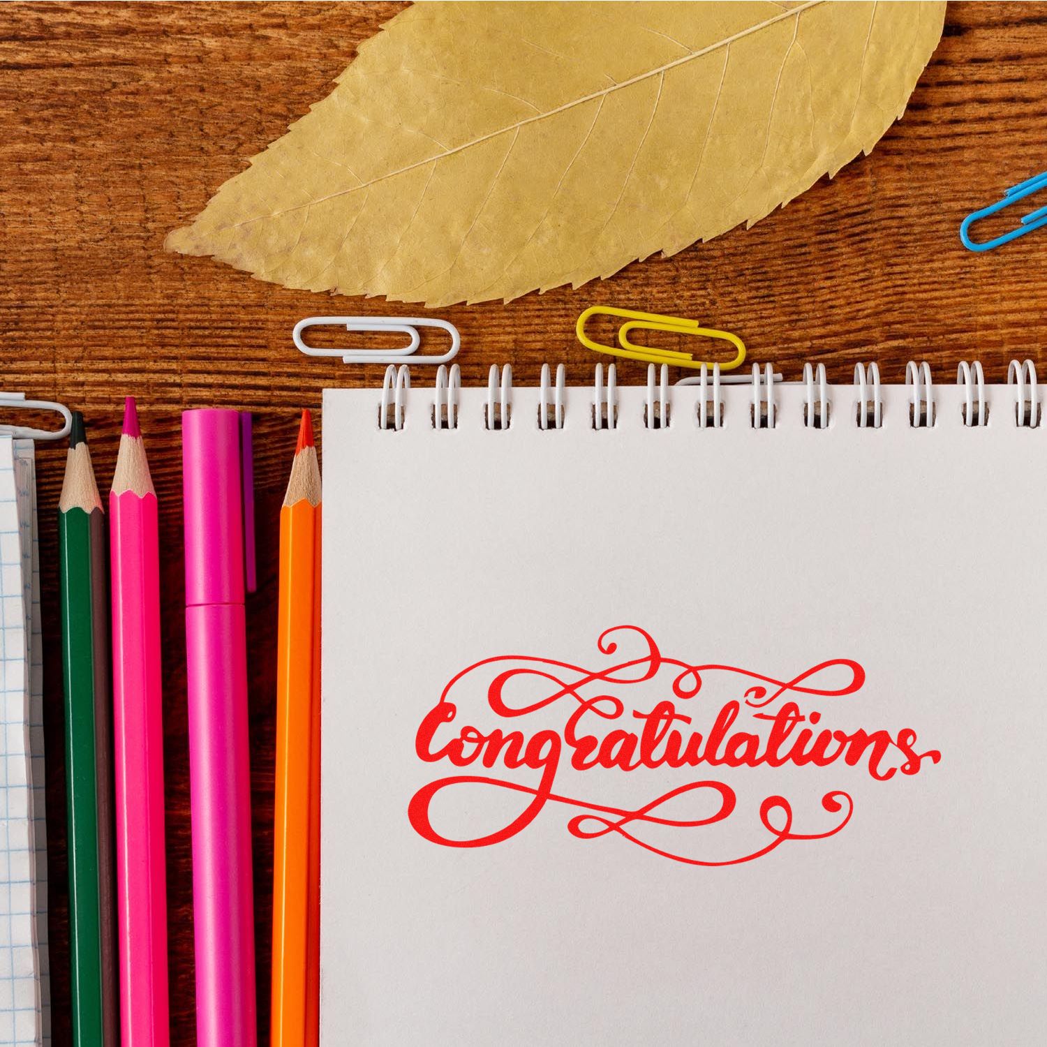 Congratulations rubber stamp design on notebook with pencils and paper clips for card making and craft projects.