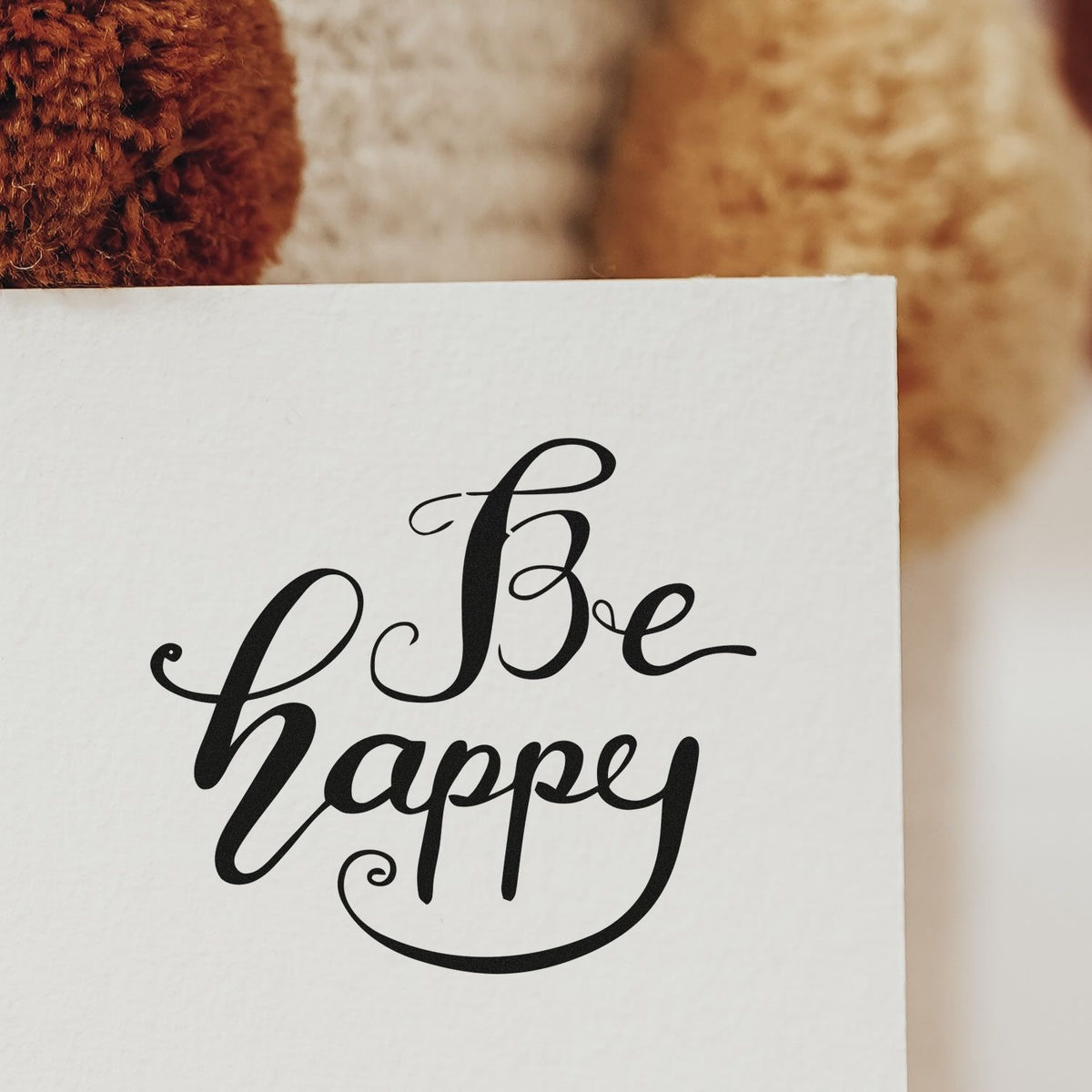 Be Happy Flowing Script Premium Wood-Mounted Stamp - Vintage Pro imprint stamped in black ink. Be happy appears in flowing calligraphy with long sweeping curves.