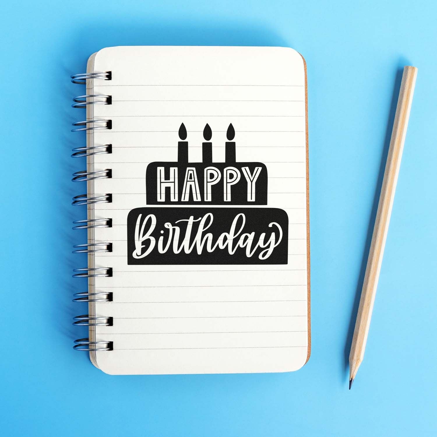 Happy Birthday rubber stamp design on a notebook page with pencil, ideal for birthday card and crafting projects.