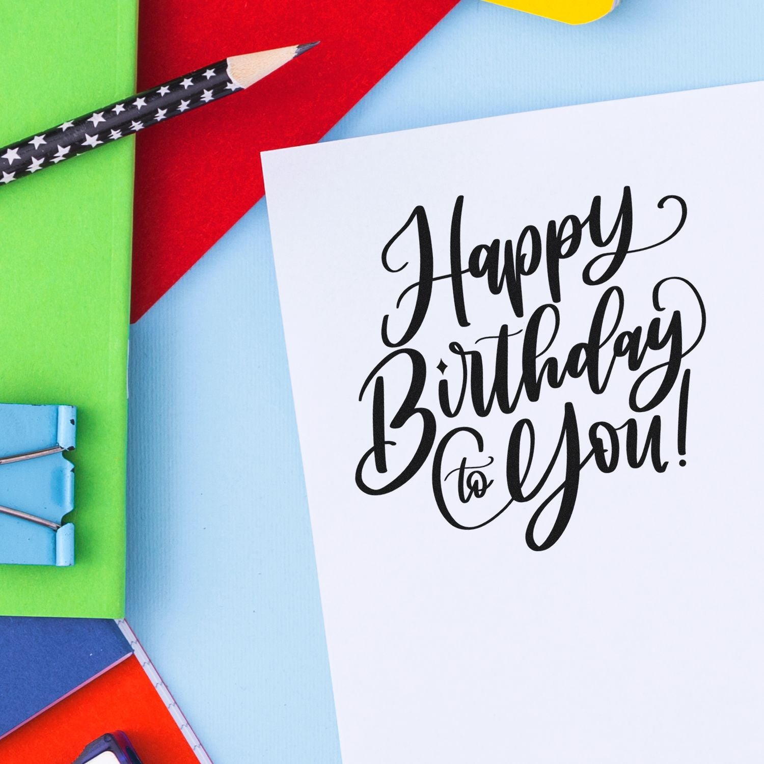 Happy Birthday to You rubber stamp design for handmade birthday cards, shown with colorful pencils and craft supplies.