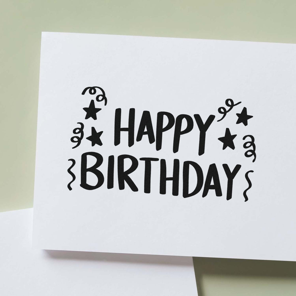 Birthday Stars And Streamers Block Lettering Premium Wooden Stamp - Vintage Pro imprint stamped in black ink. HAPPY BIRTHDAY appears in hand-drawn capitals surrounded by stars and curling streamers.