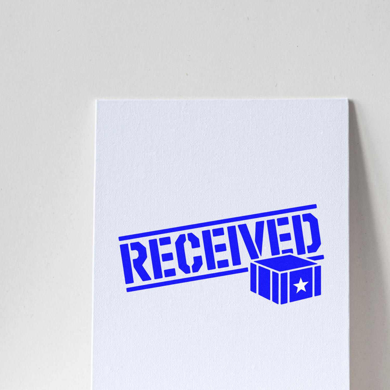Blue RECEIVED rubber stamp impression with package icon on white paper for mail, shipping, and inventory processing.