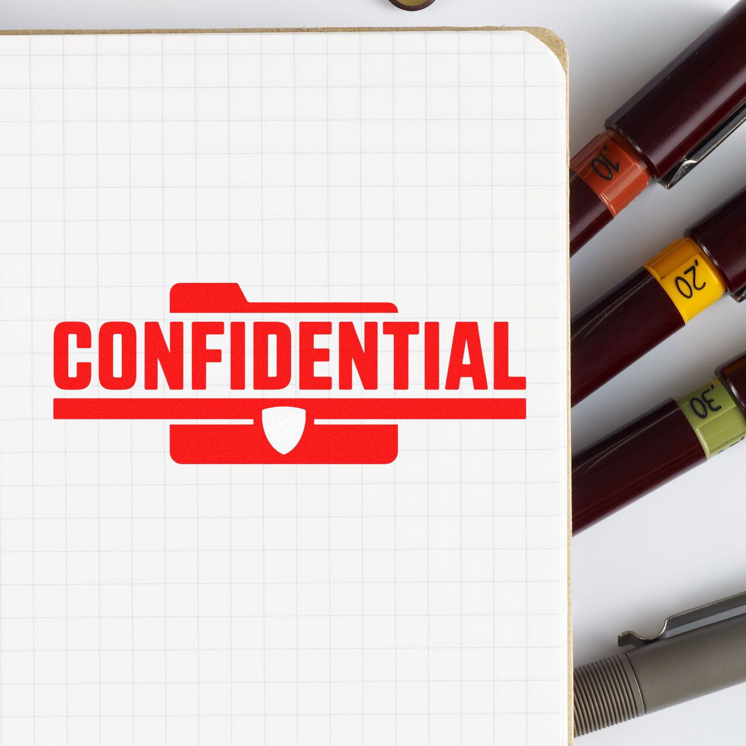 Confidential rubber stamp on notebook, ideal for document security labeling and office organization.