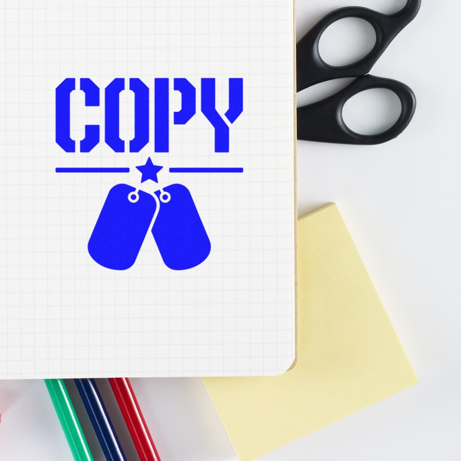 Blue COPY rubber stamp design on notebook with office scissors, pens, and sticky note for paperwork labeling.