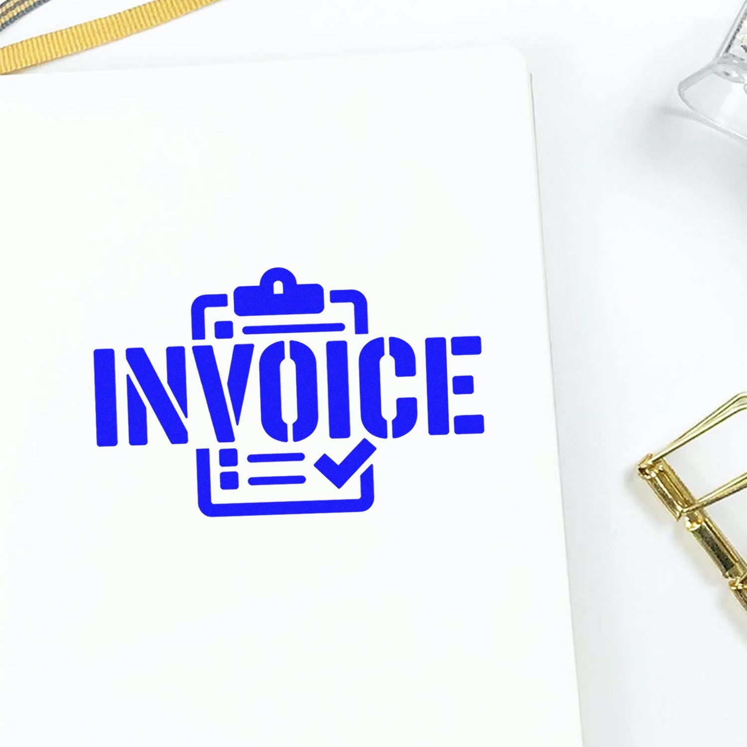Blue invoice rubber stamp on paper for business billing, accounting, and office document approval.