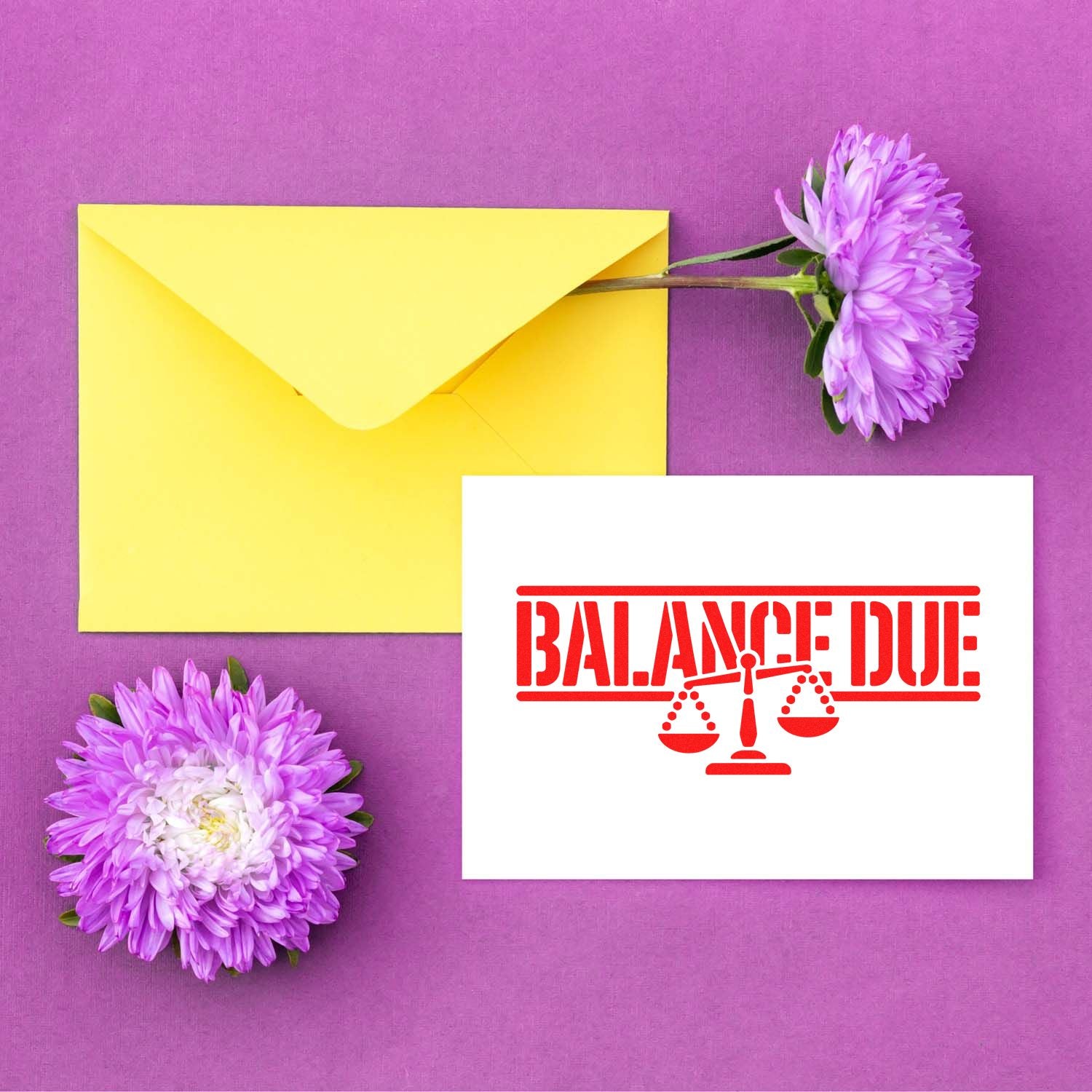 Balance Due rubber stamp design with scales icon on a card, shown beside a yellow envelope and purple flowers