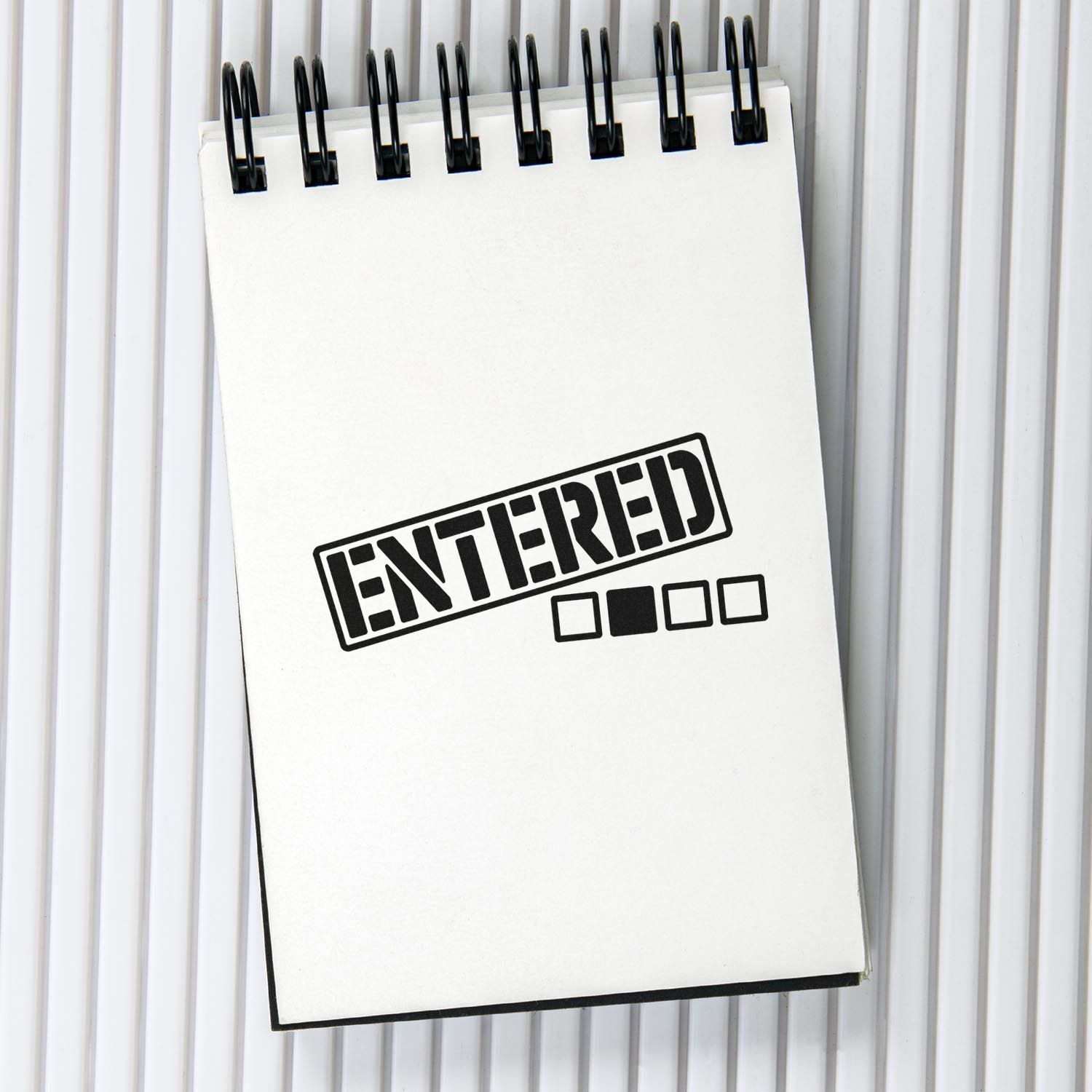 ENTERED rubber stamp imprint on notebook paper for office document processing and file tracking.