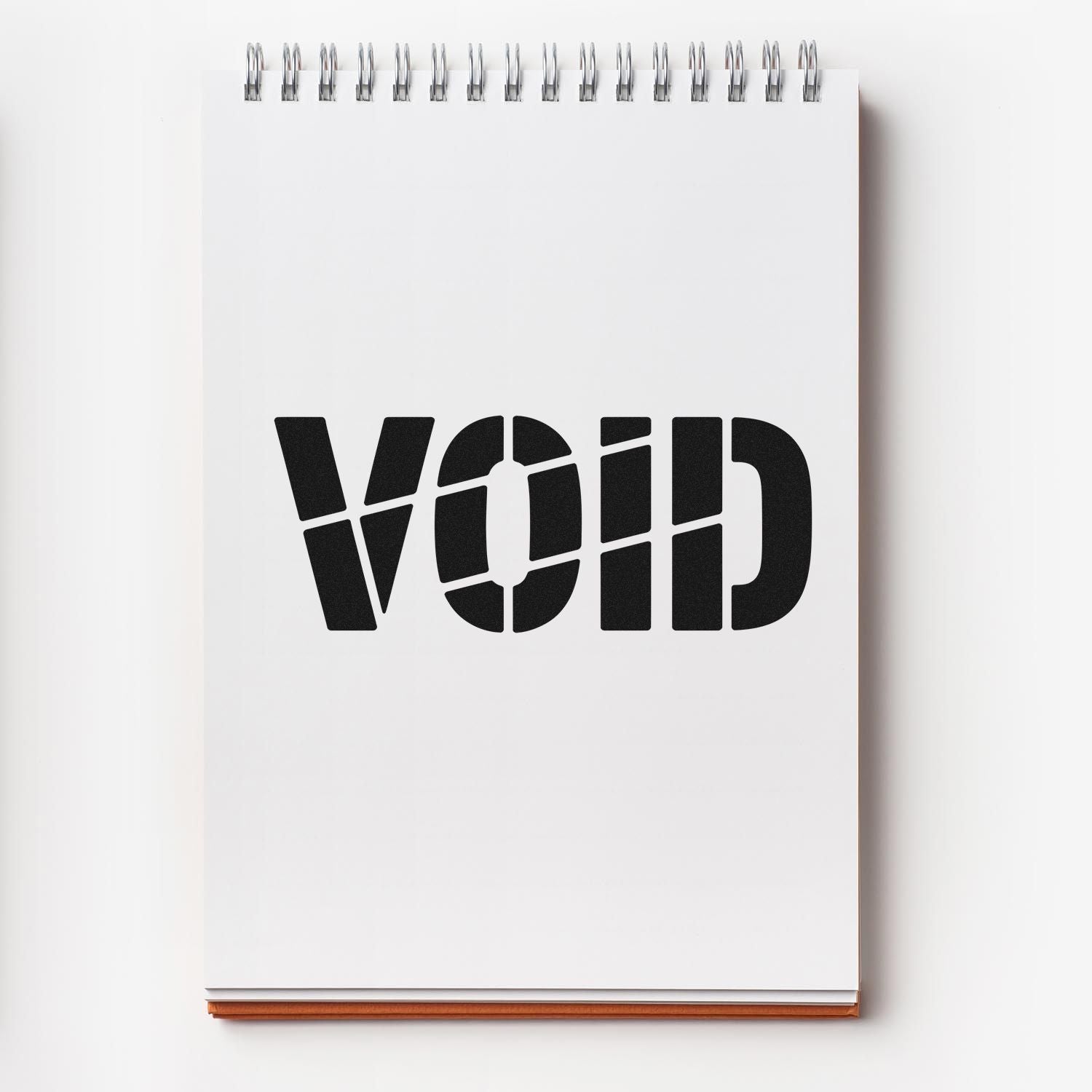 VOID rubber stamp impression on a blank spiral notepad