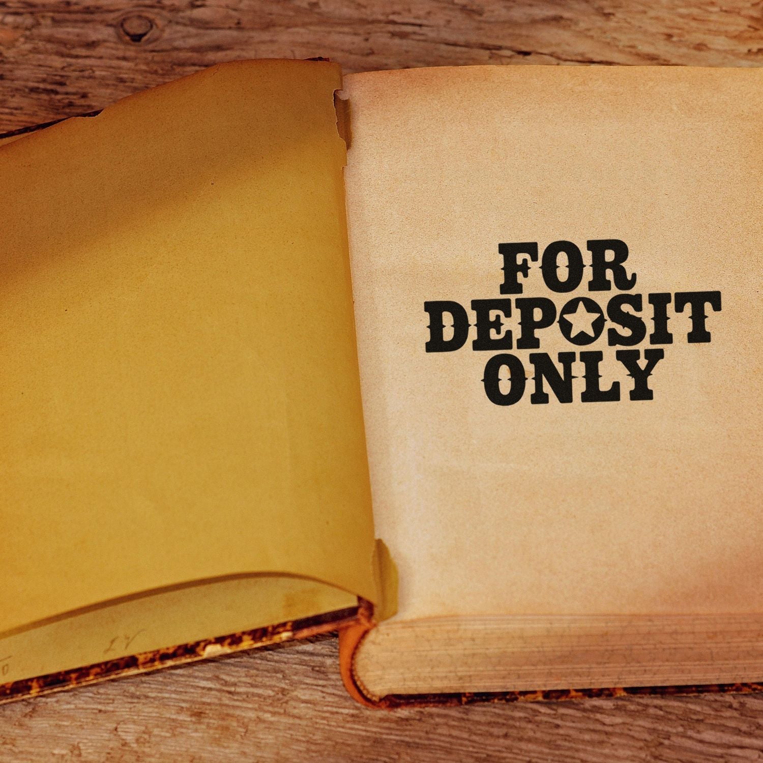 For Deposit Only rubber stamp on open book page, ideal for bank endorsement and secure check processing.