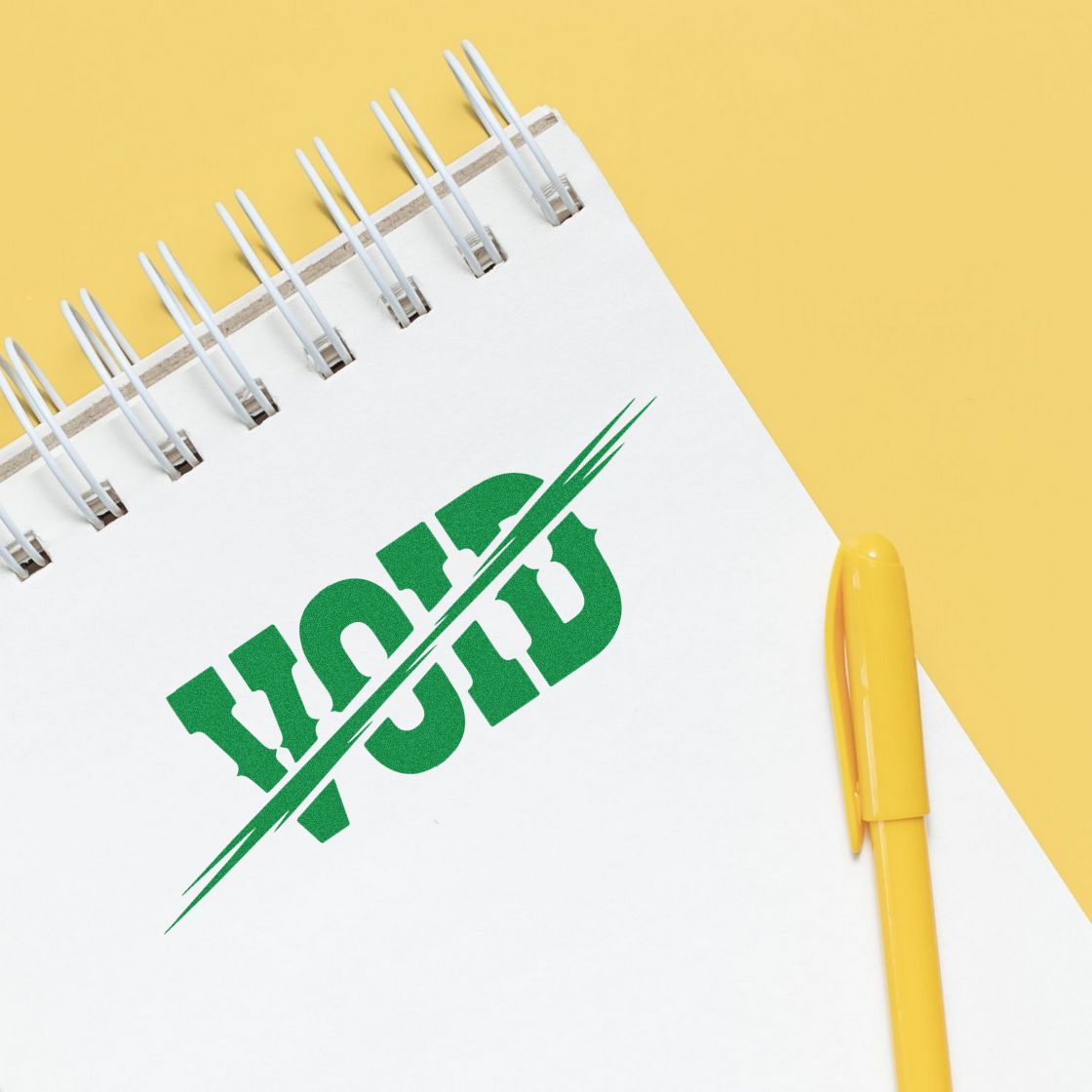 Green VOID rubber stamp on notebook, showing canceled or invalid document approval for office and business use.