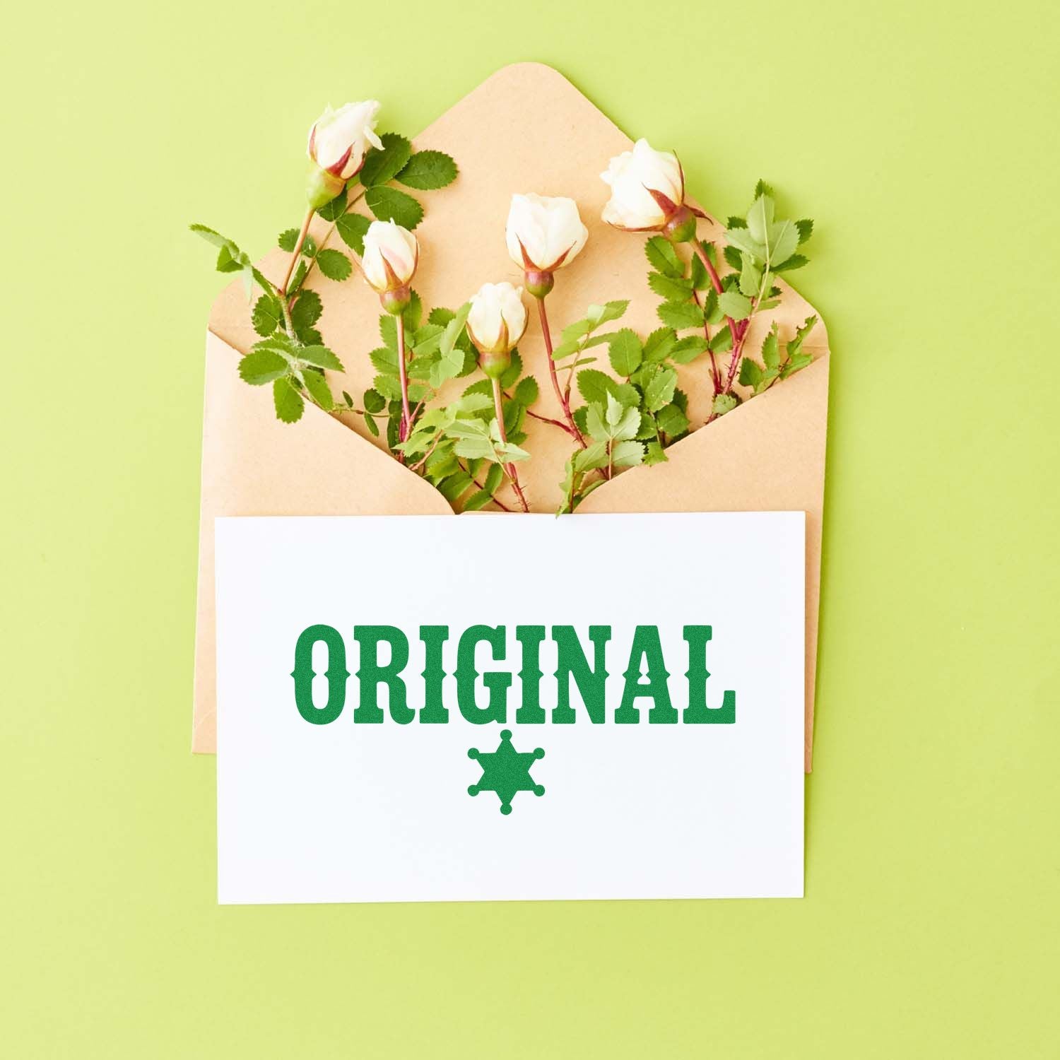 Original rubber stamp design with green lettering and star icon on a card, shown in an envelope with flowers.