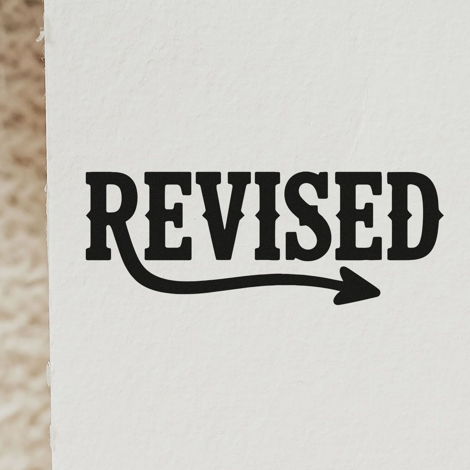 Revised rubber stamp design with bold text and right-pointing arrow for document edits and approval marking