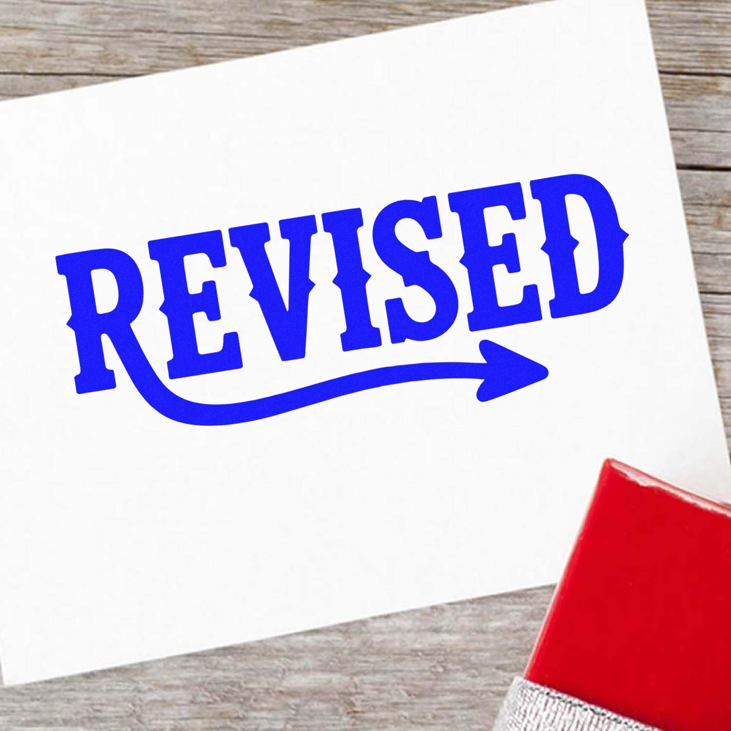 Blue revised rubber stamp imprint on paper for document review and approval