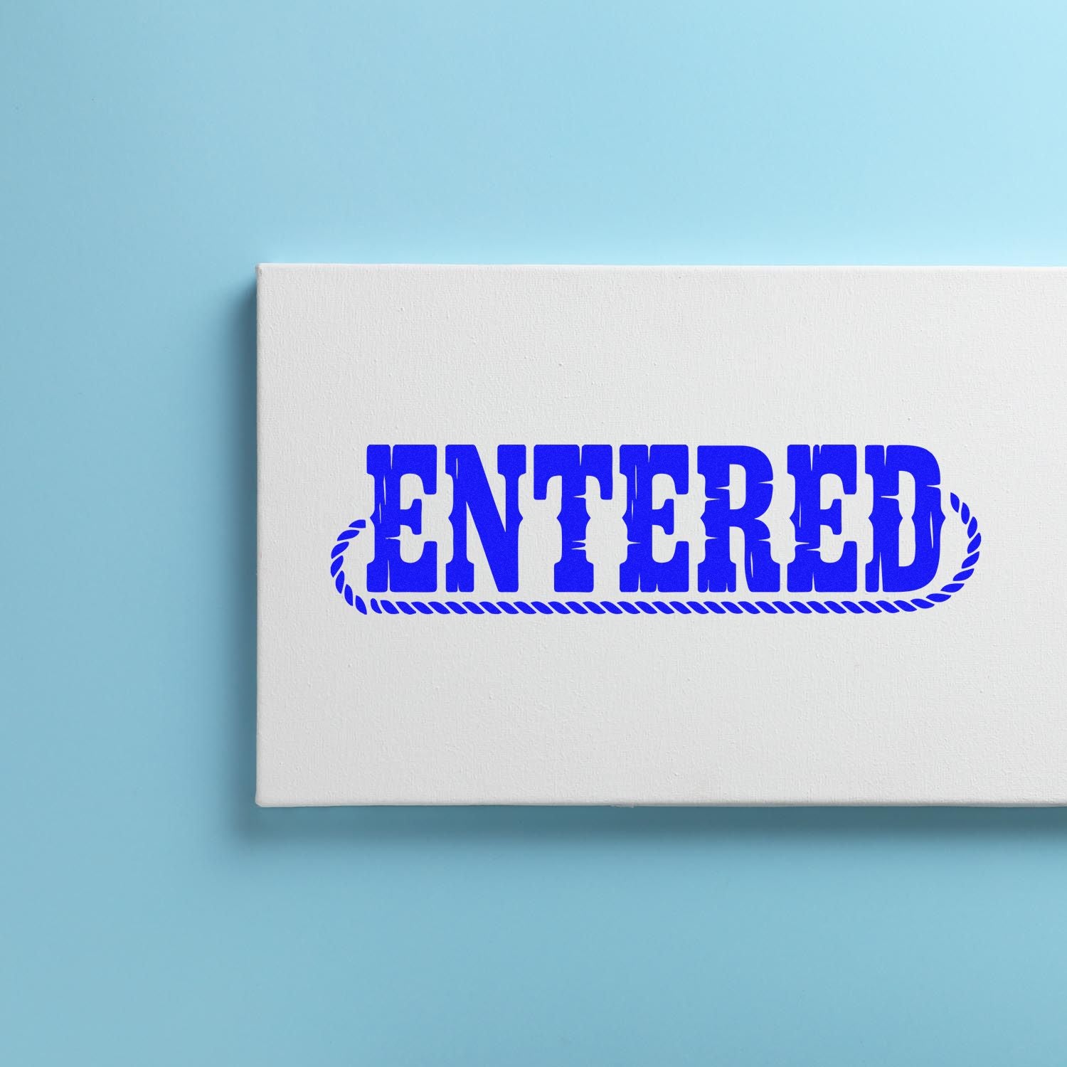 Blue ENTERED rubber stamp impression on white card for office document processing and record marking.