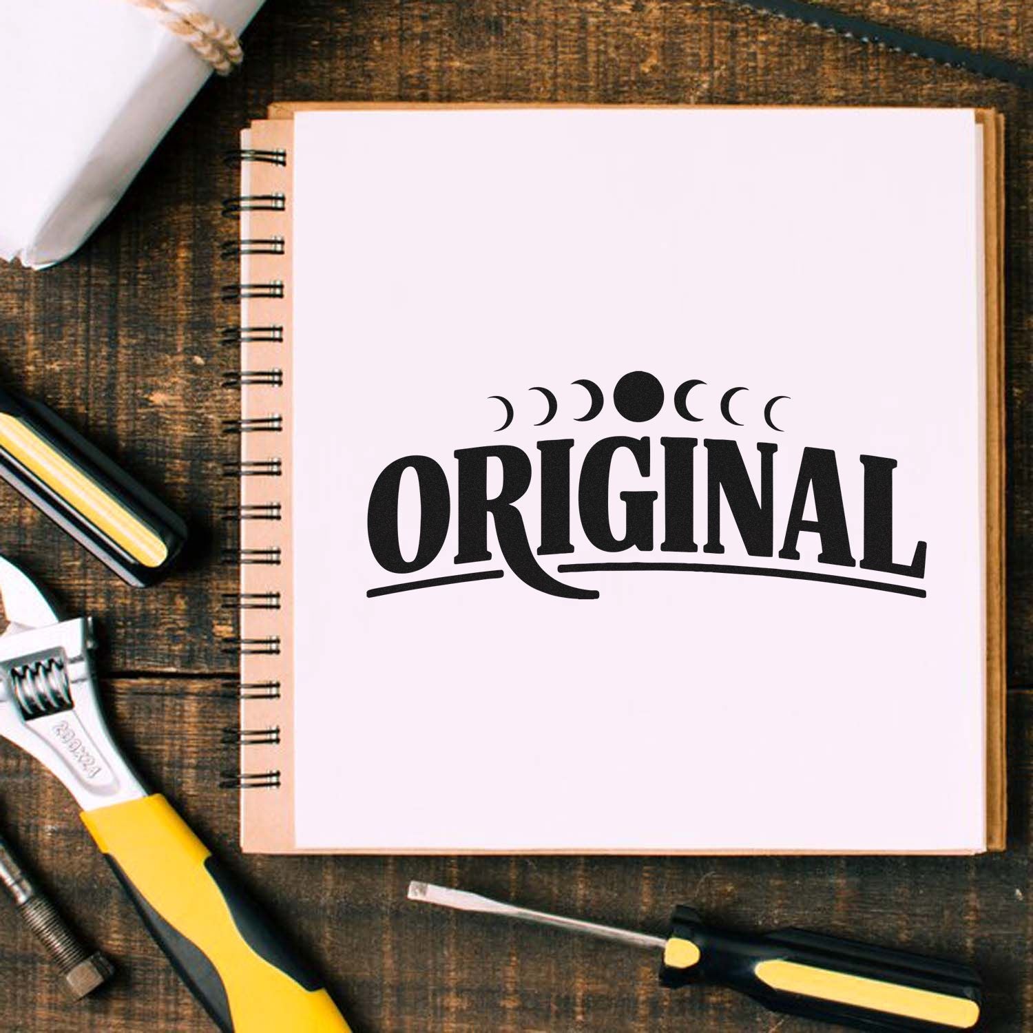 Original rubber stamp design for notebooks, branding, and handmade packaging with craft tools on a desk.