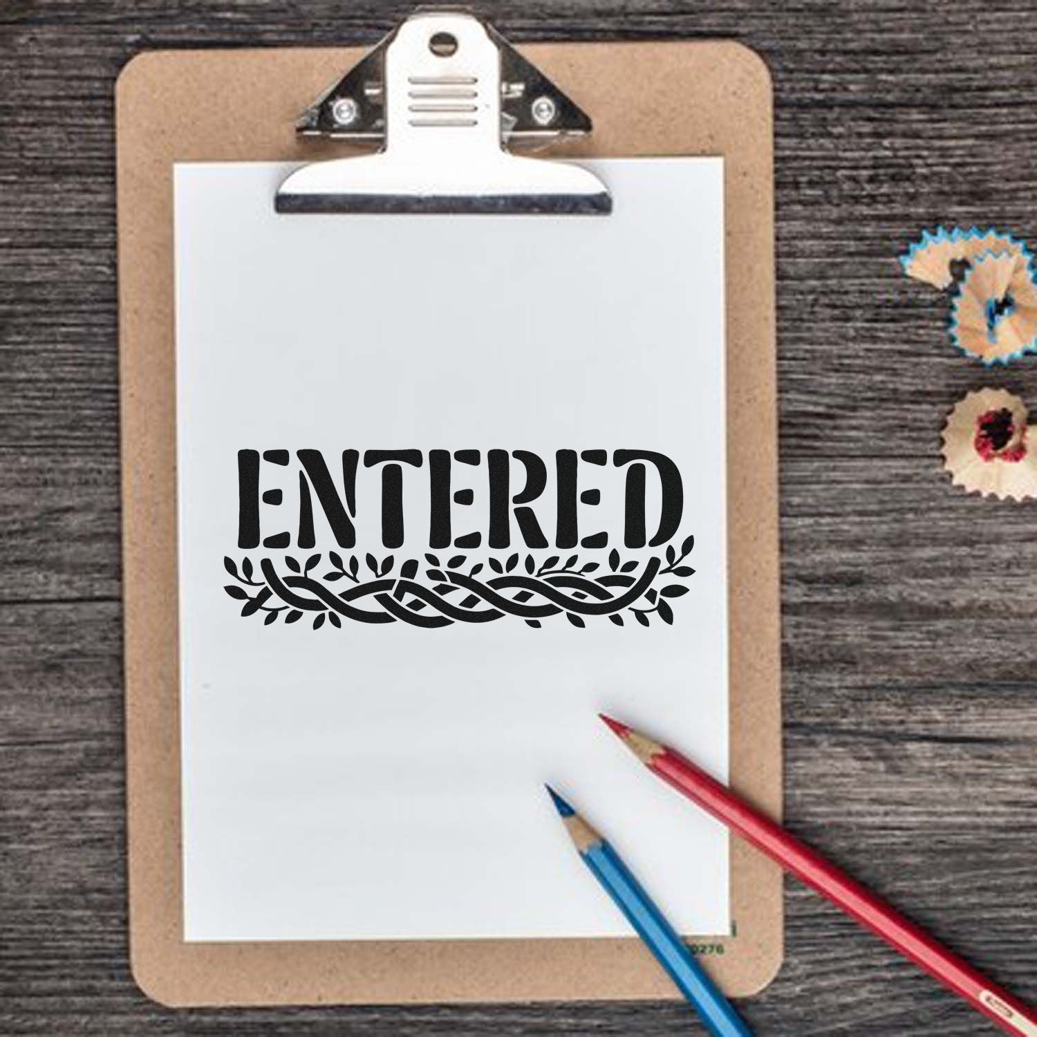ENTERED rubber stamp design on clipboard, black decorative office approval stamp for paperwork and forms.