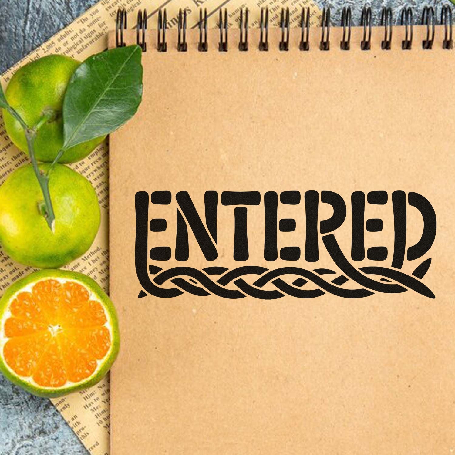 Entered rubber stamp design on kraft notebook, framed by citrus and leaves, for planners, journals, and craft projects.