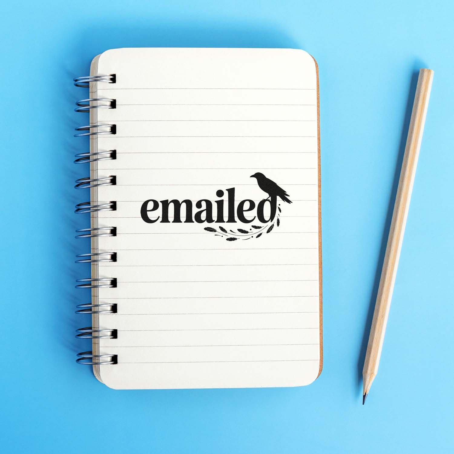 Emailed rubber stamp design on a spiral notebook with bird graphic, ideal for office and mail-themed crafting.