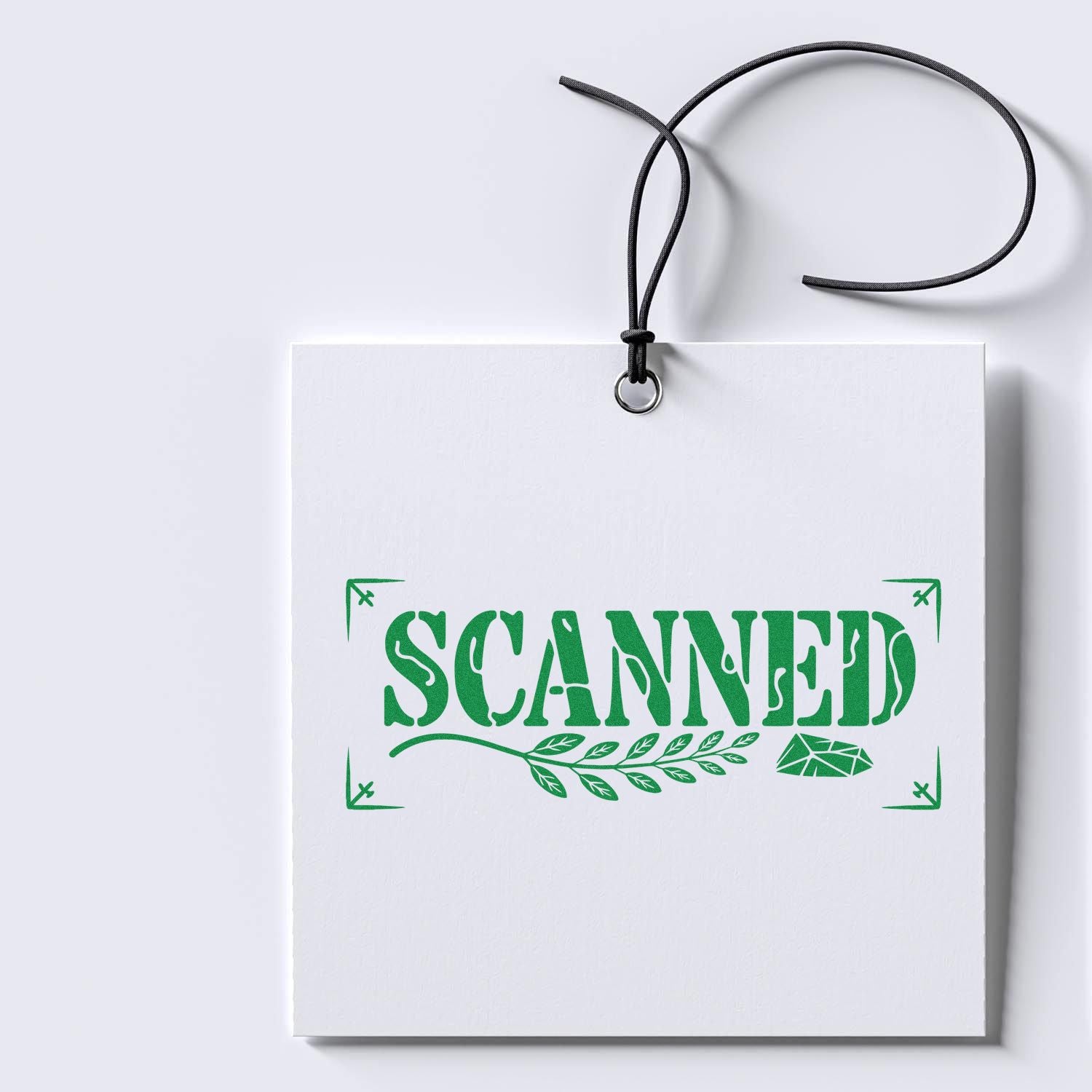 Green SCANNED rubber stamp on white hanging tag, perfect for document processing, office use, and record tracking.