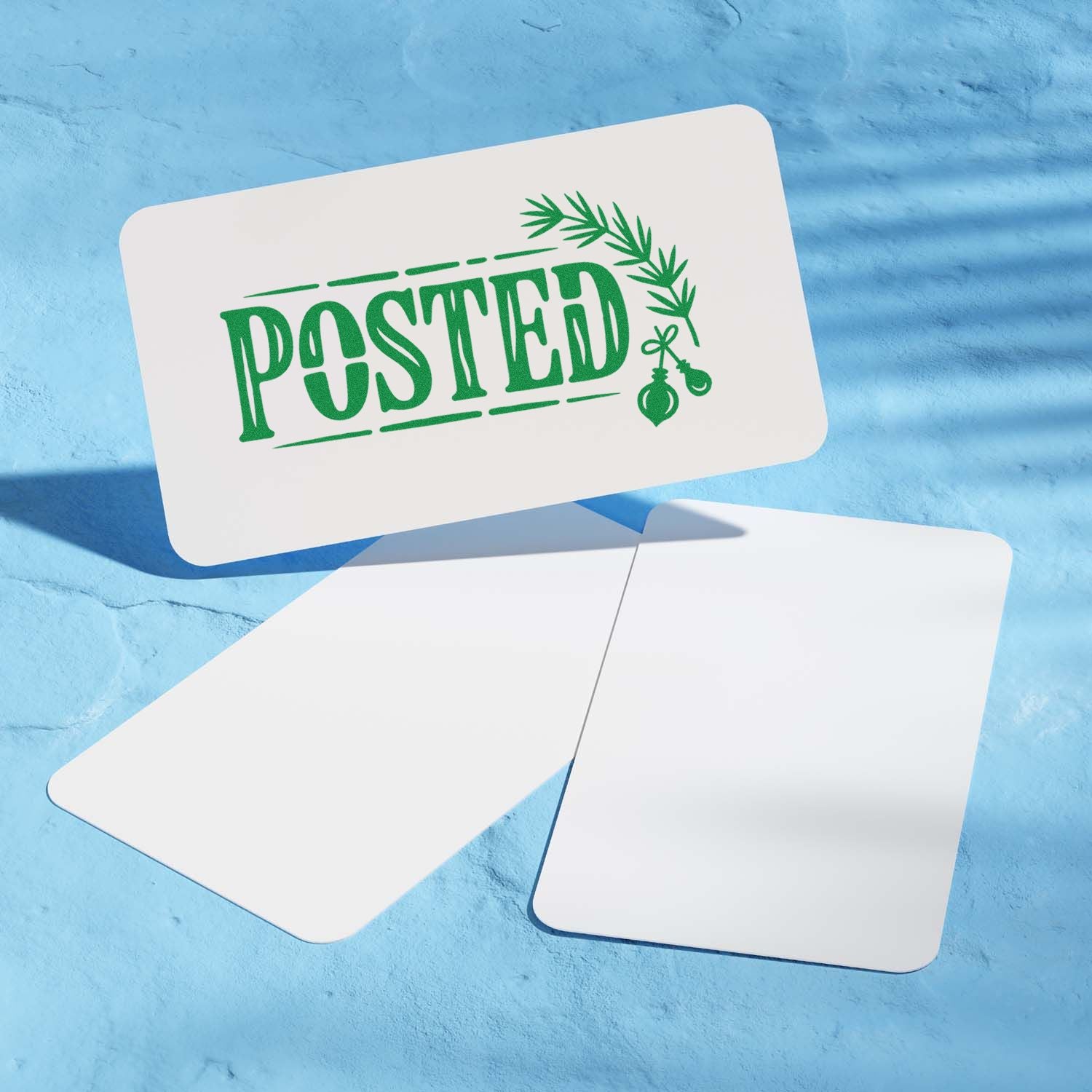 Holiday rubber stamp mockup with green POSTED design and festive greenery on white cards