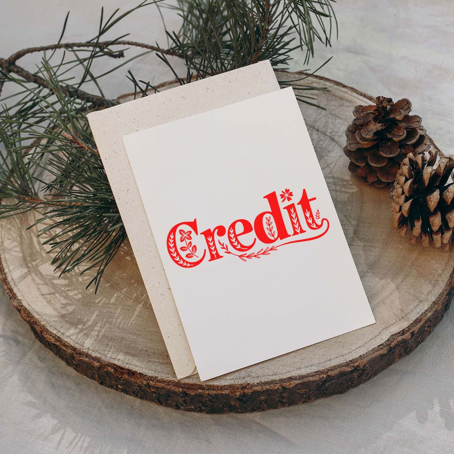 Custom decorative credit rubber stamp imprint on holiday stationery with pine branches and pinecones