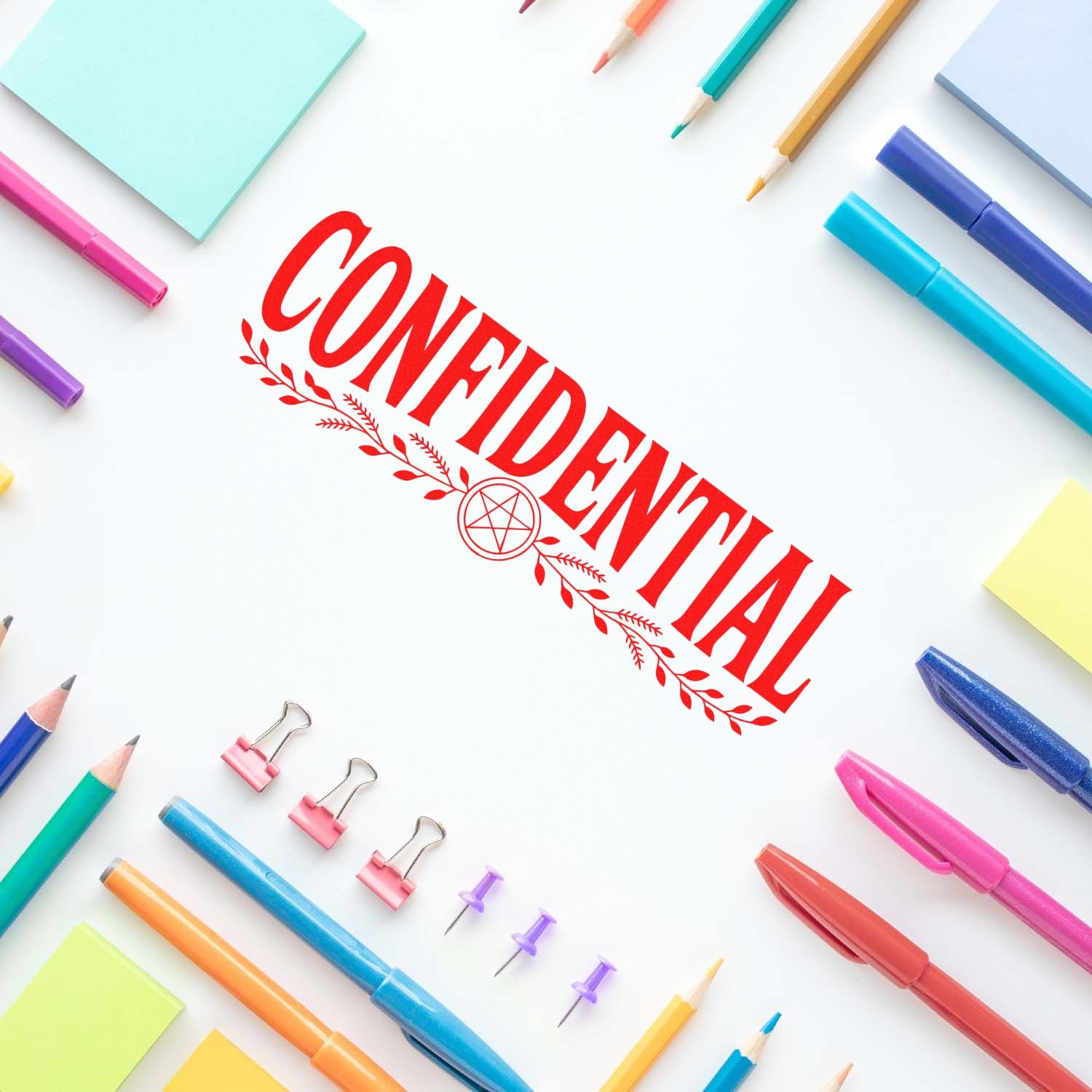 Confidential rubber stamp impression on paper with colorful stationery, perfect for office document privacy marking.