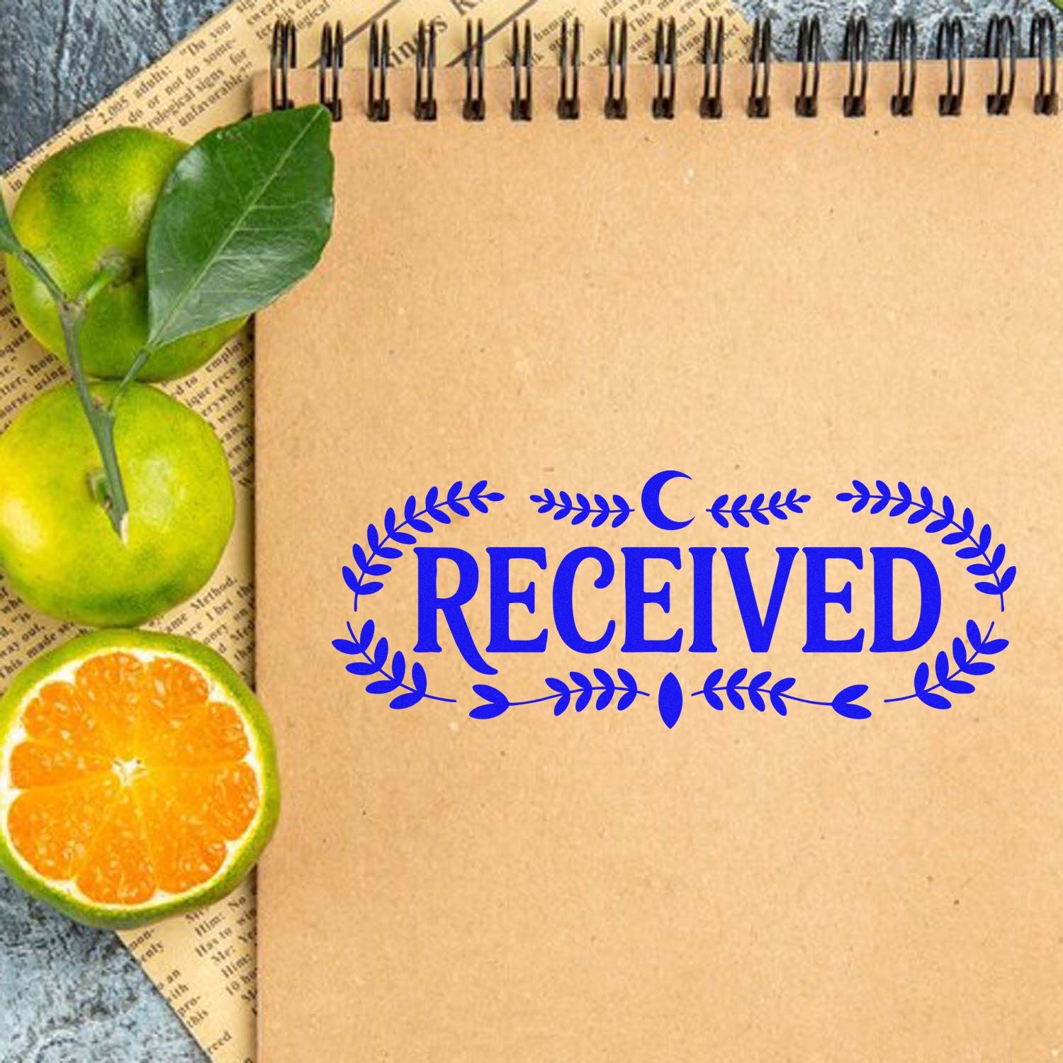 Blue RECEIVED rubber stamp design with wreath border on kraft notebook, ideal for office document handling and mail receipt.