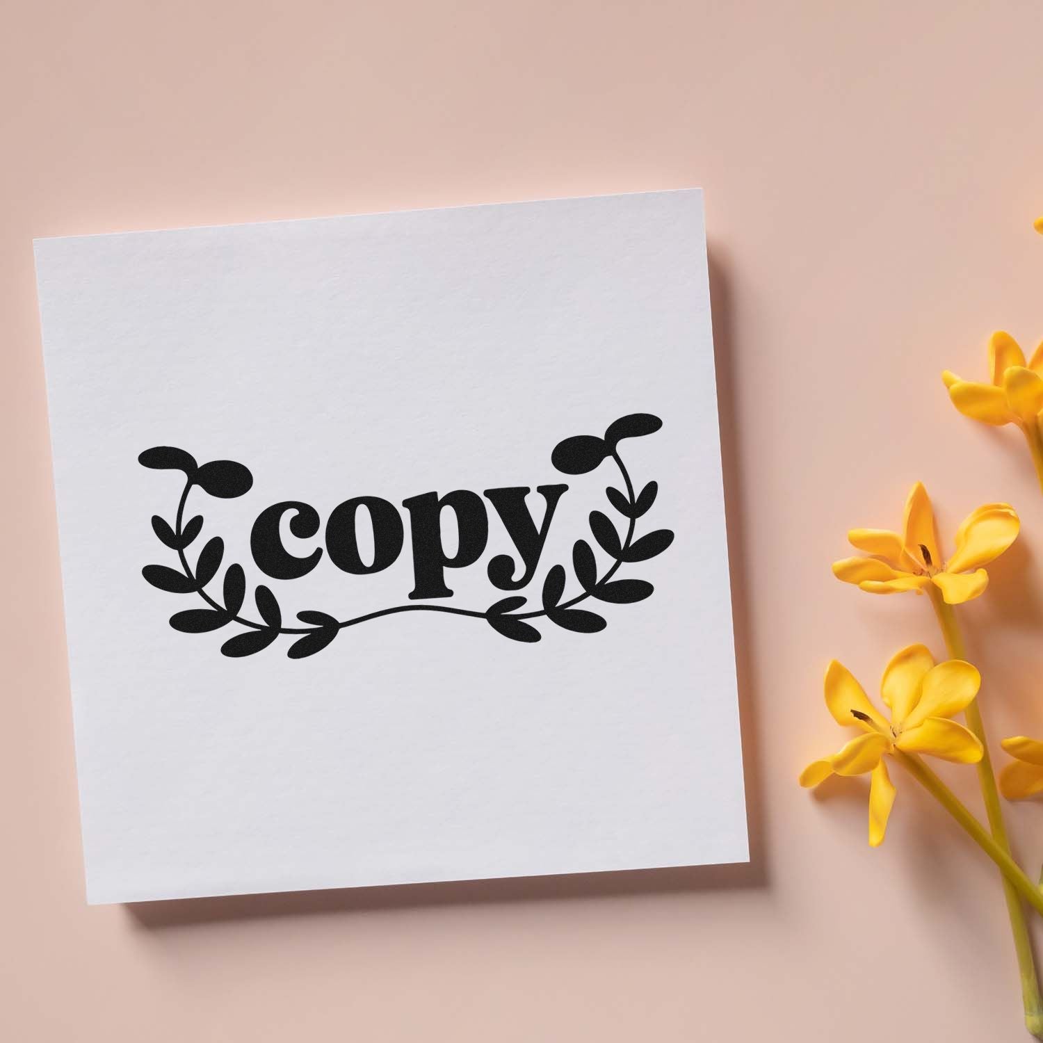 Custom copy rubber stamp with decorative leafy wreath, shown on white paper for handmade packaging and office labeling.