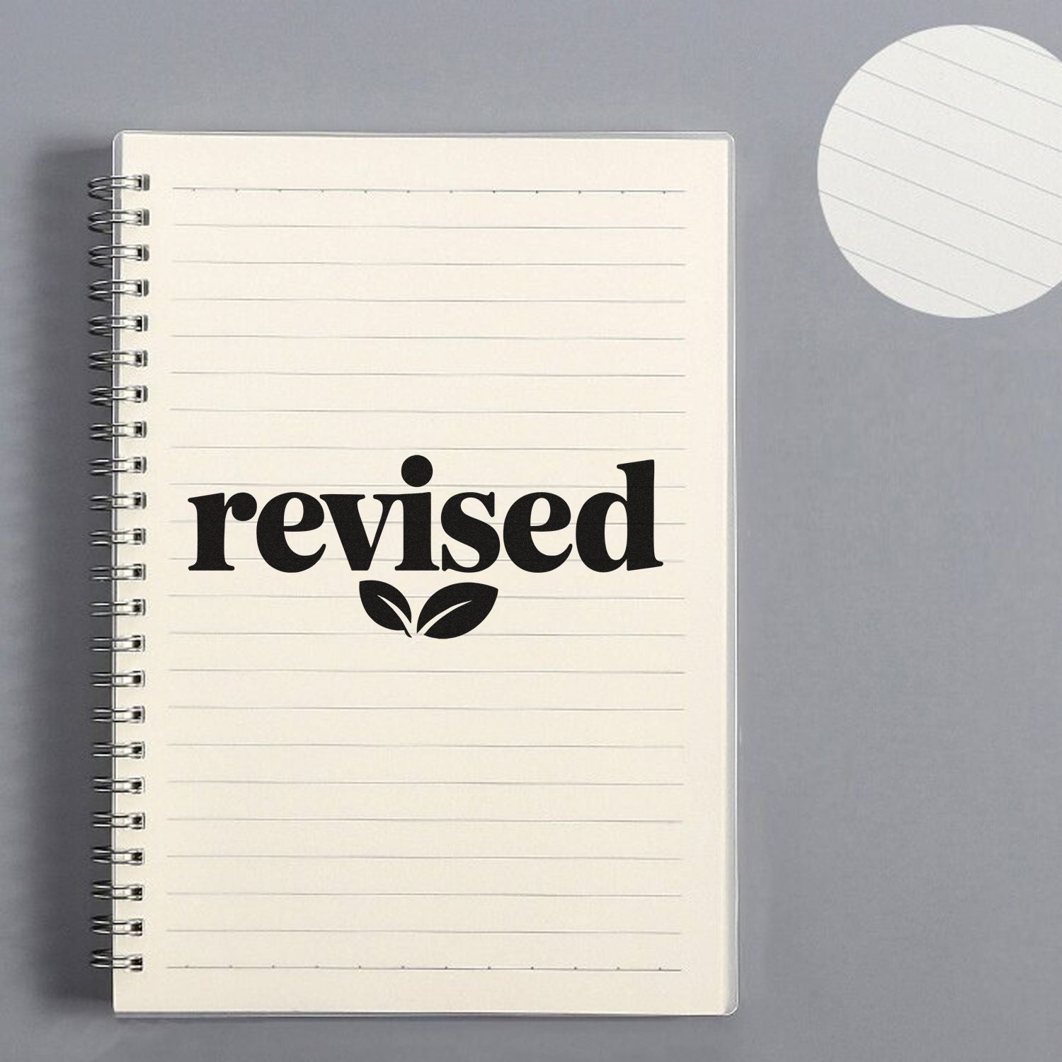 Revised rubber stamp design on lined notebook page, ideal for office document review and approval.