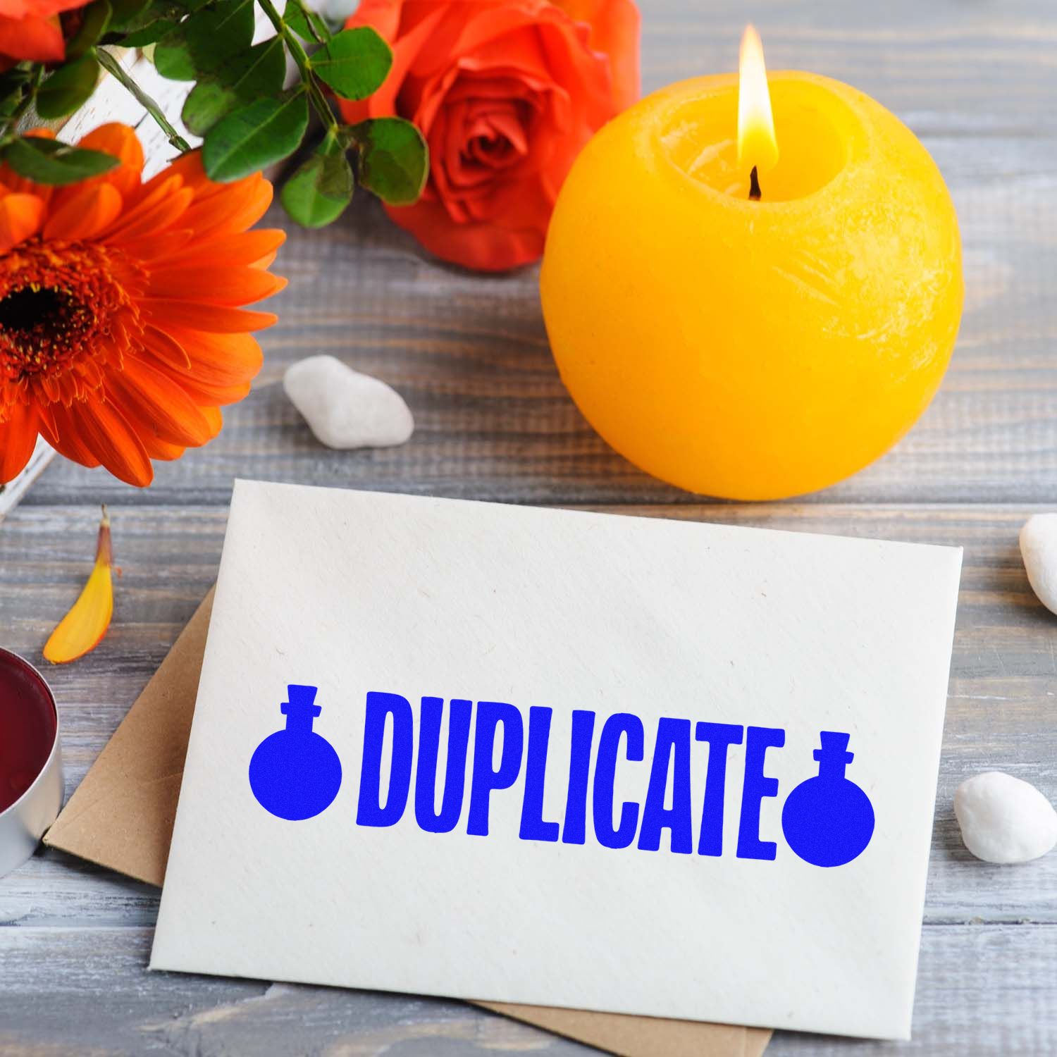 Duplicate rubber stamp text on envelope, shown with flowers and candle for office document marking