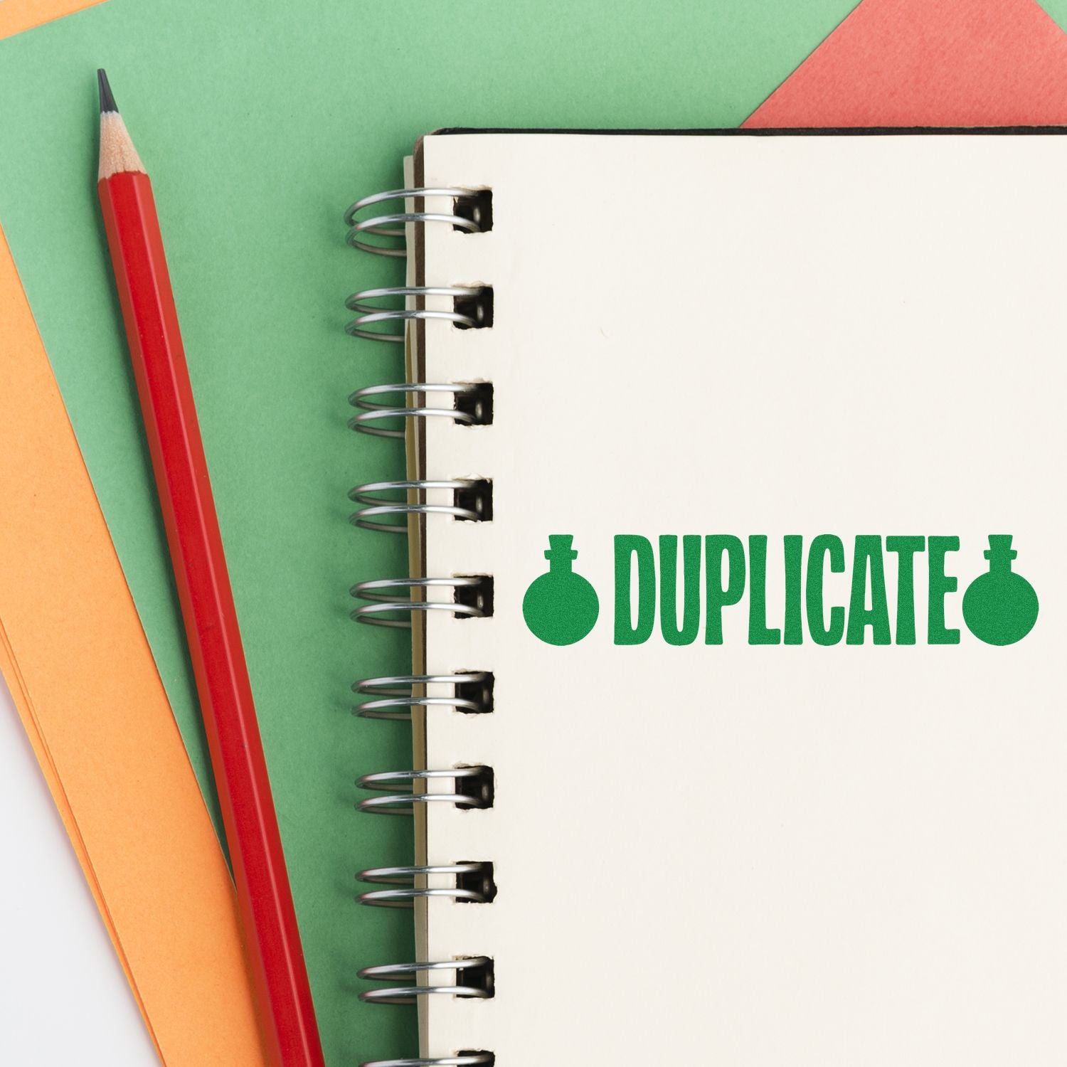 Green DUPLICATE rubber stamp on notebook page for office document marking and file organization.