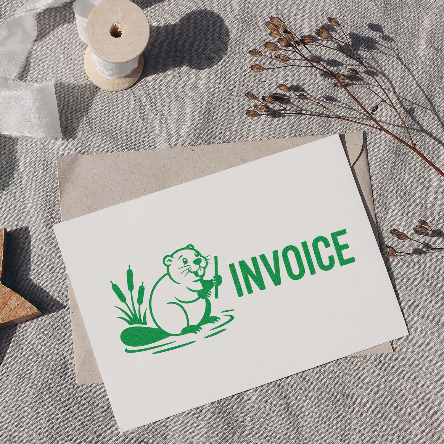 Green invoice rubber stamp with beaver logo on stationery for branded business billing and paperwork.