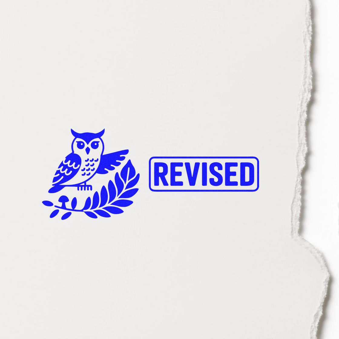 Blue REVISED rubber stamp with owl and laurel design for approving edited documents.