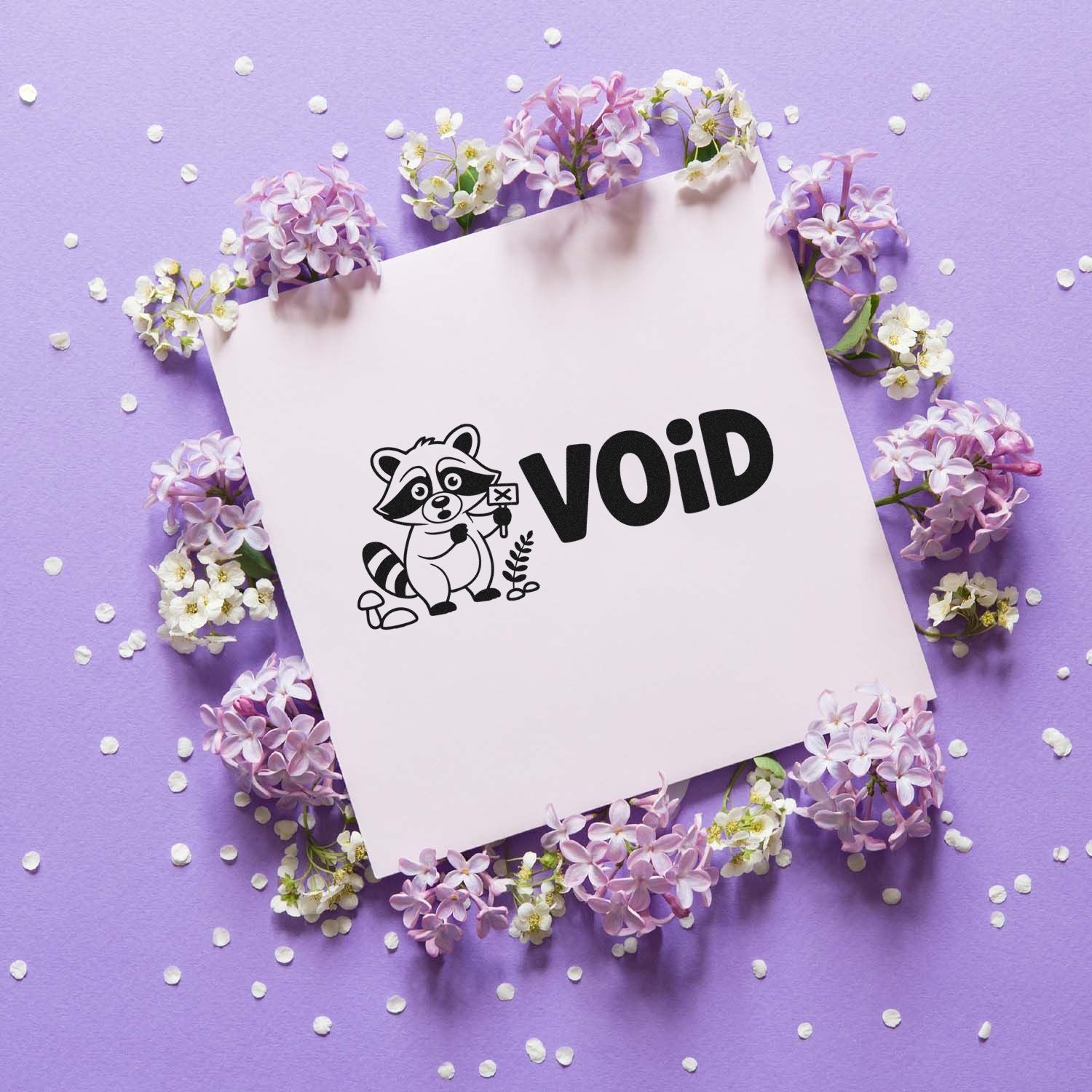 Cute raccoon VOID rubber stamp design for marking documents, shown on paper with lilac flowers.