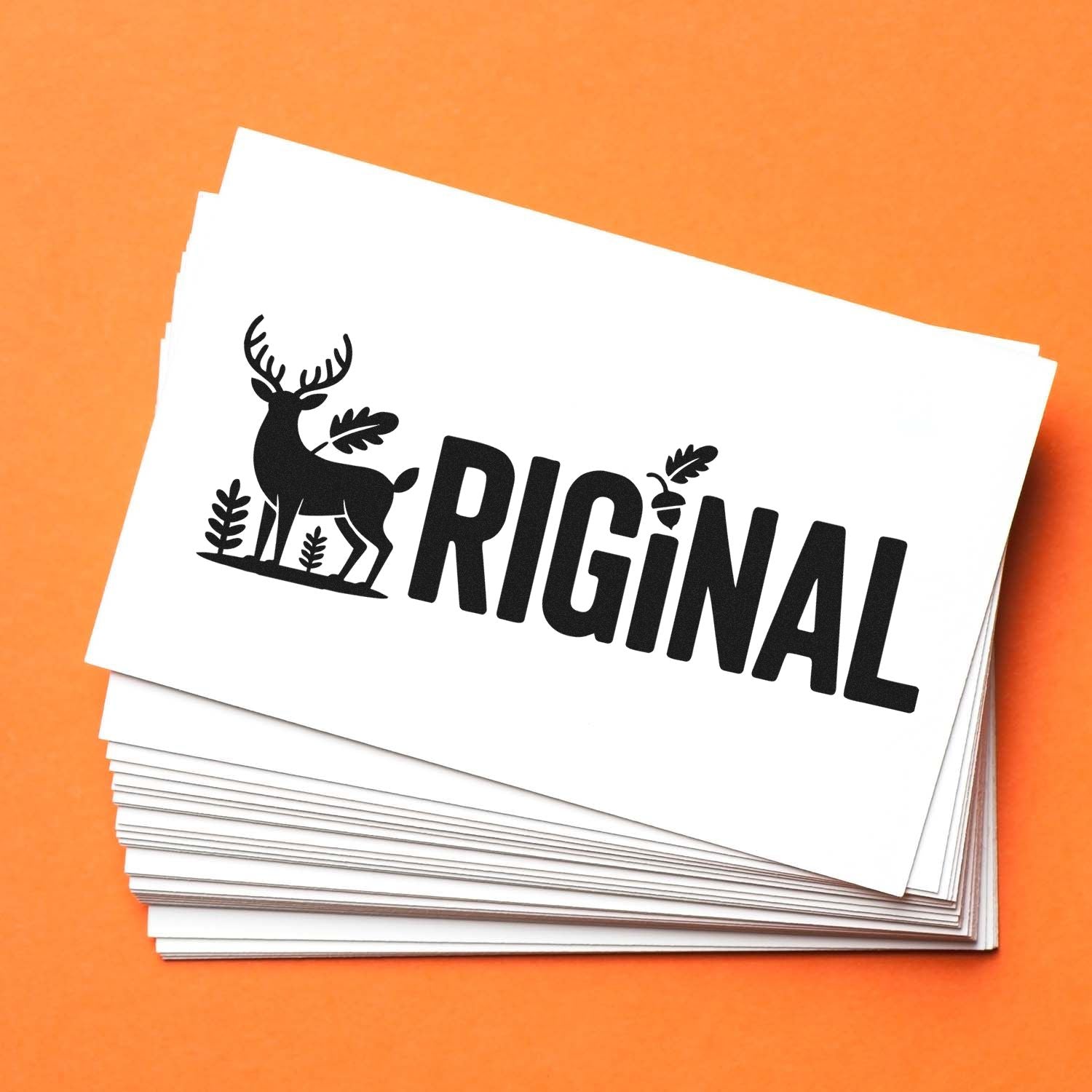 Custom rubber stamp with deer logo and ORIGINAL text on stacked cards for branding, packaging, or stationery.