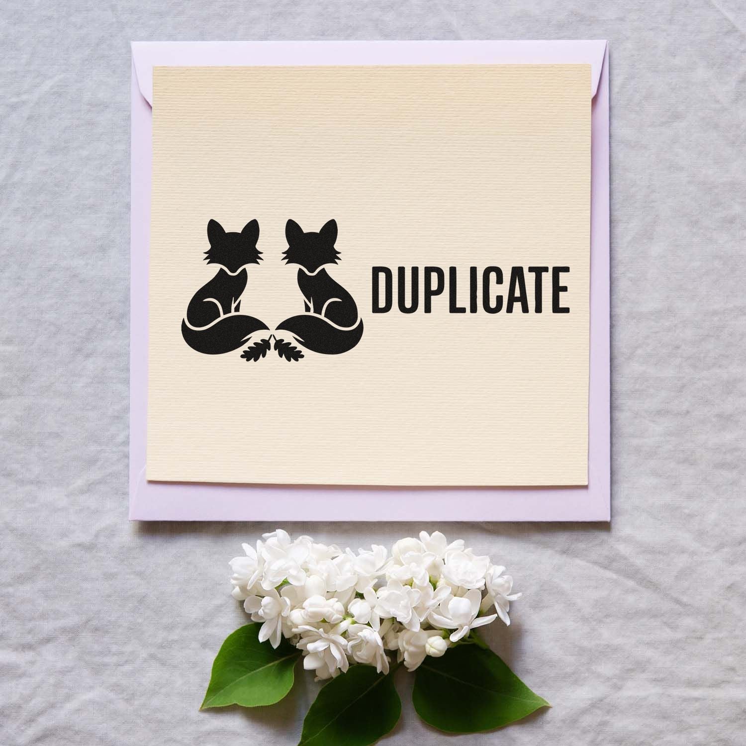Duplicate rubber stamp with twin fox design for marking copies on stationery and packaging.