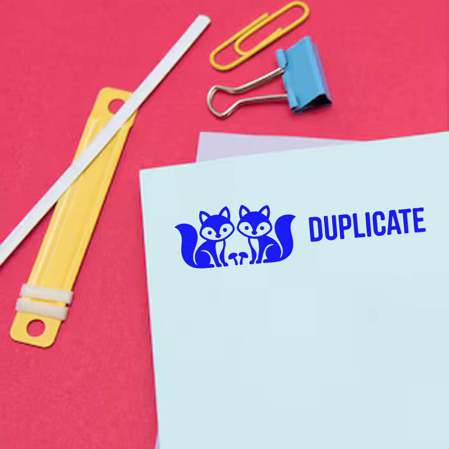 Duplicate rubber stamp on office paperwork with fox logo, ideal for marking copies and filing documents.