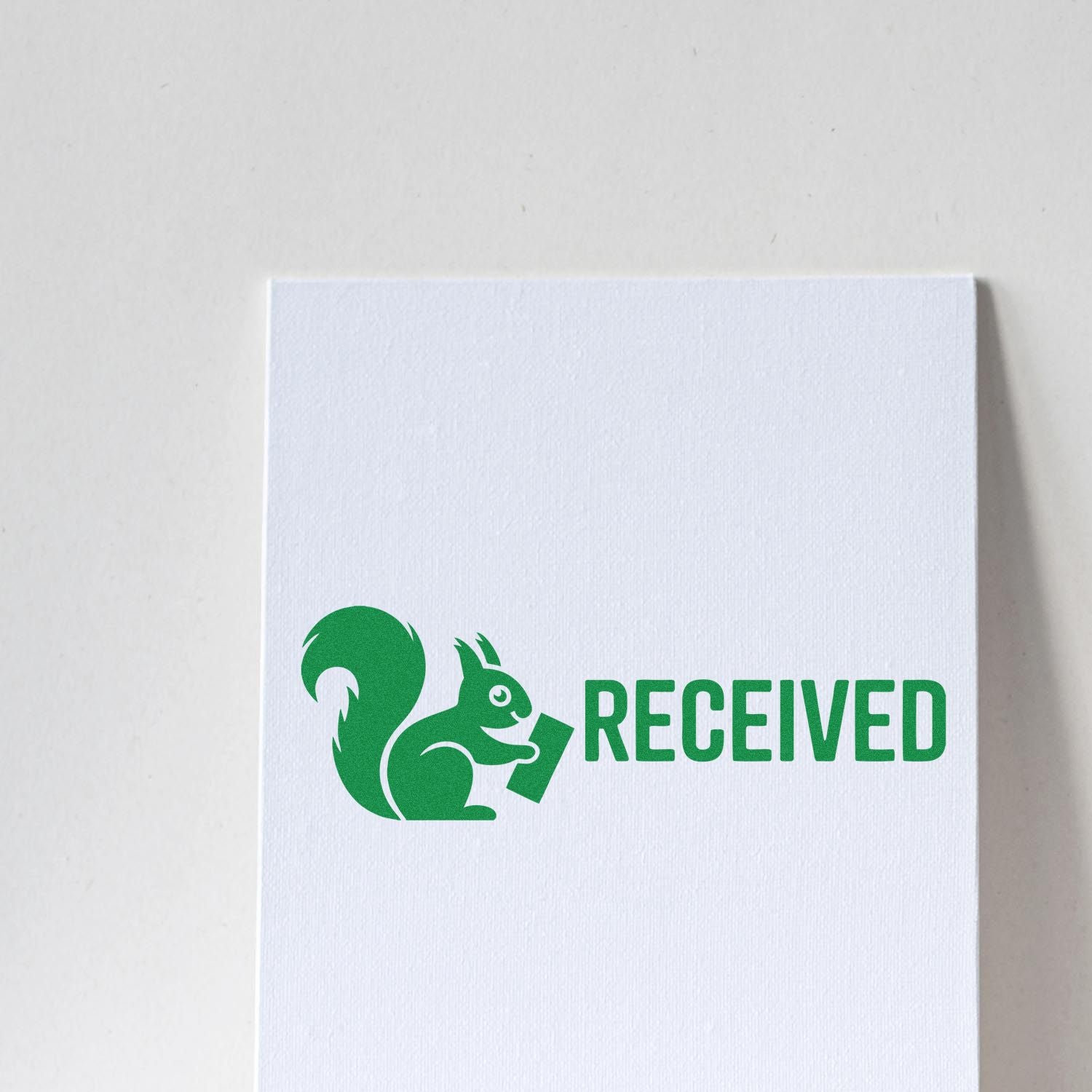 Green squirrel RECEIVED rubber stamp on white paper, ideal for office documents and custom business use.