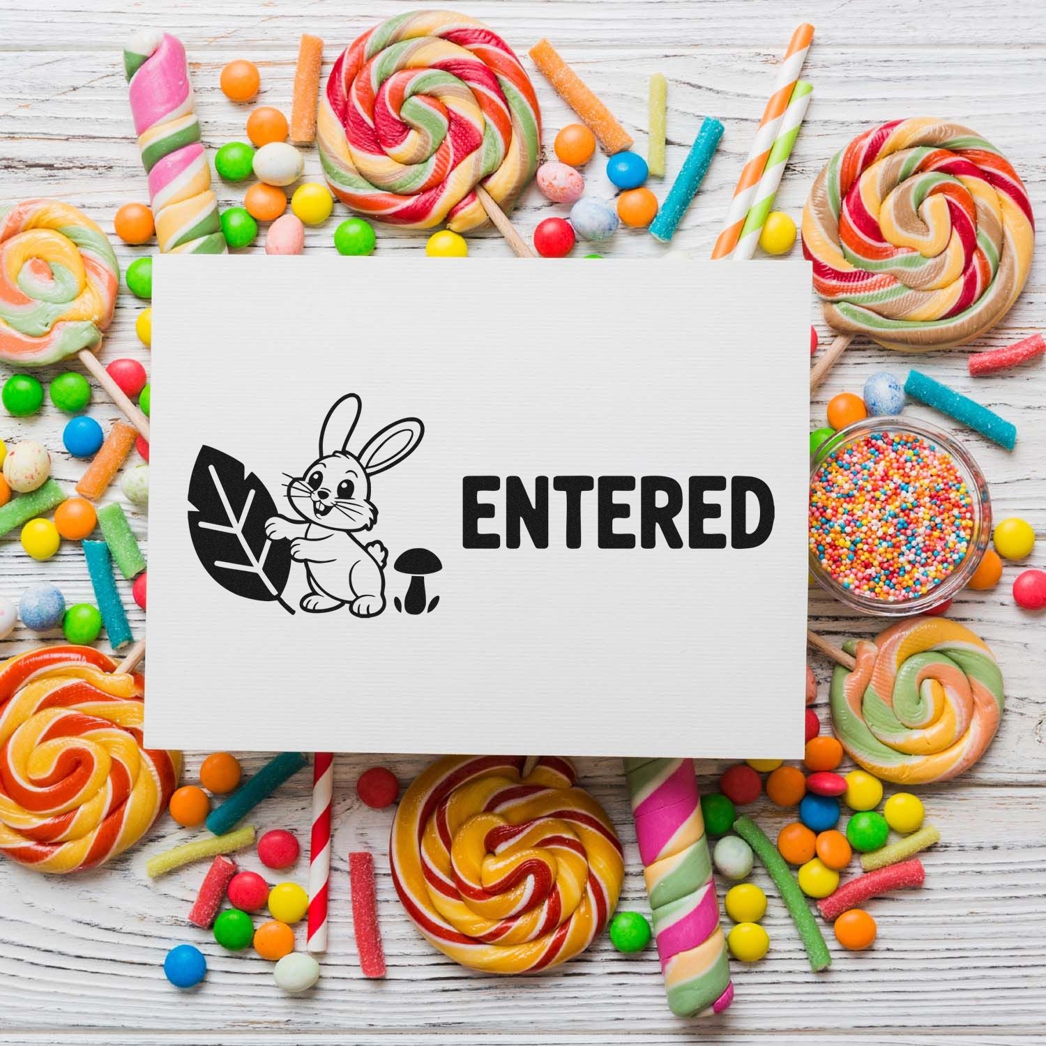 Entered bunny rubber stamp design for craft projects, displayed on a white card with a colorful candy background.